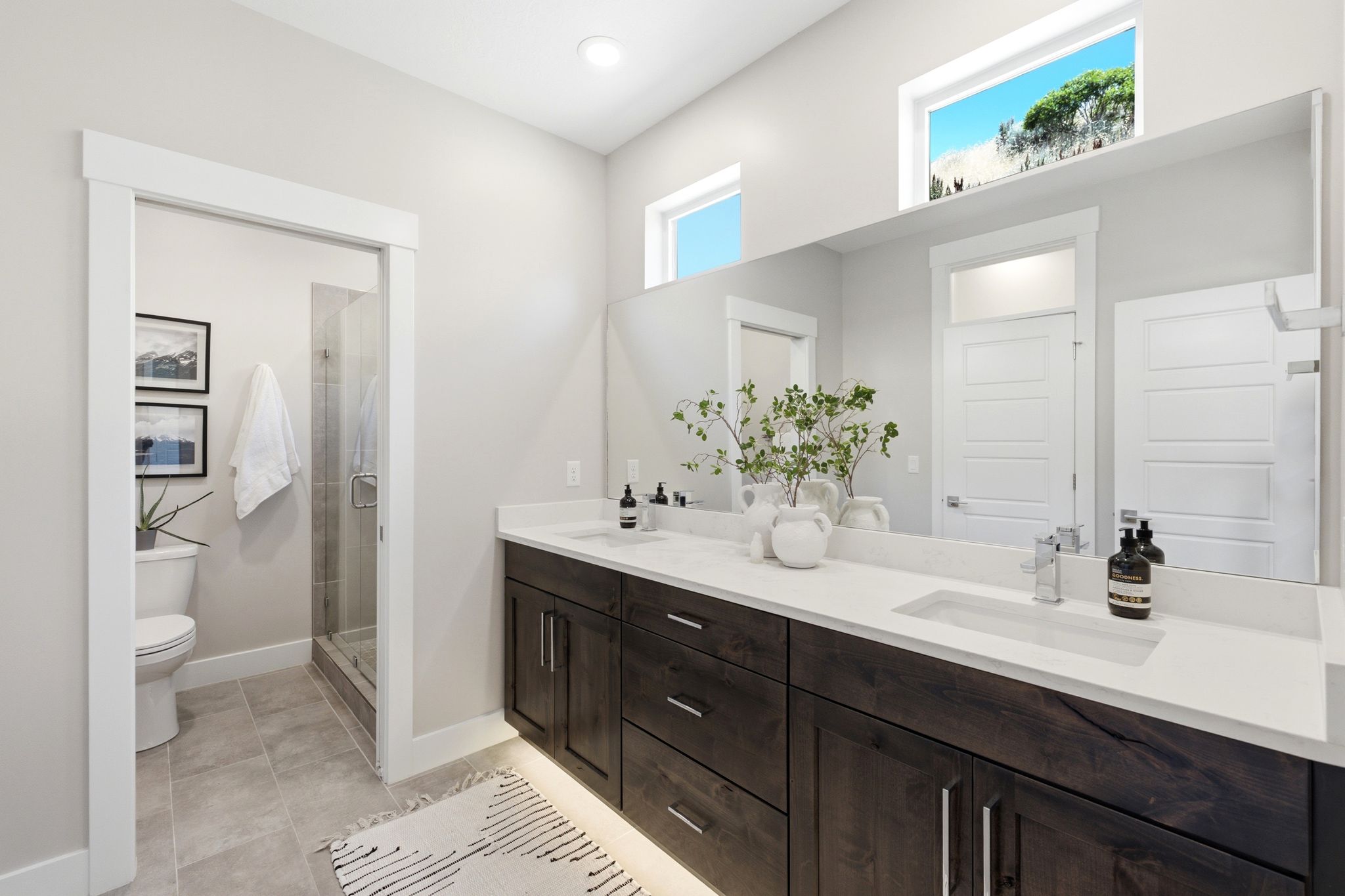 Spacious bathroom featuring a dual vanity with integrated sinks and quartz countertops