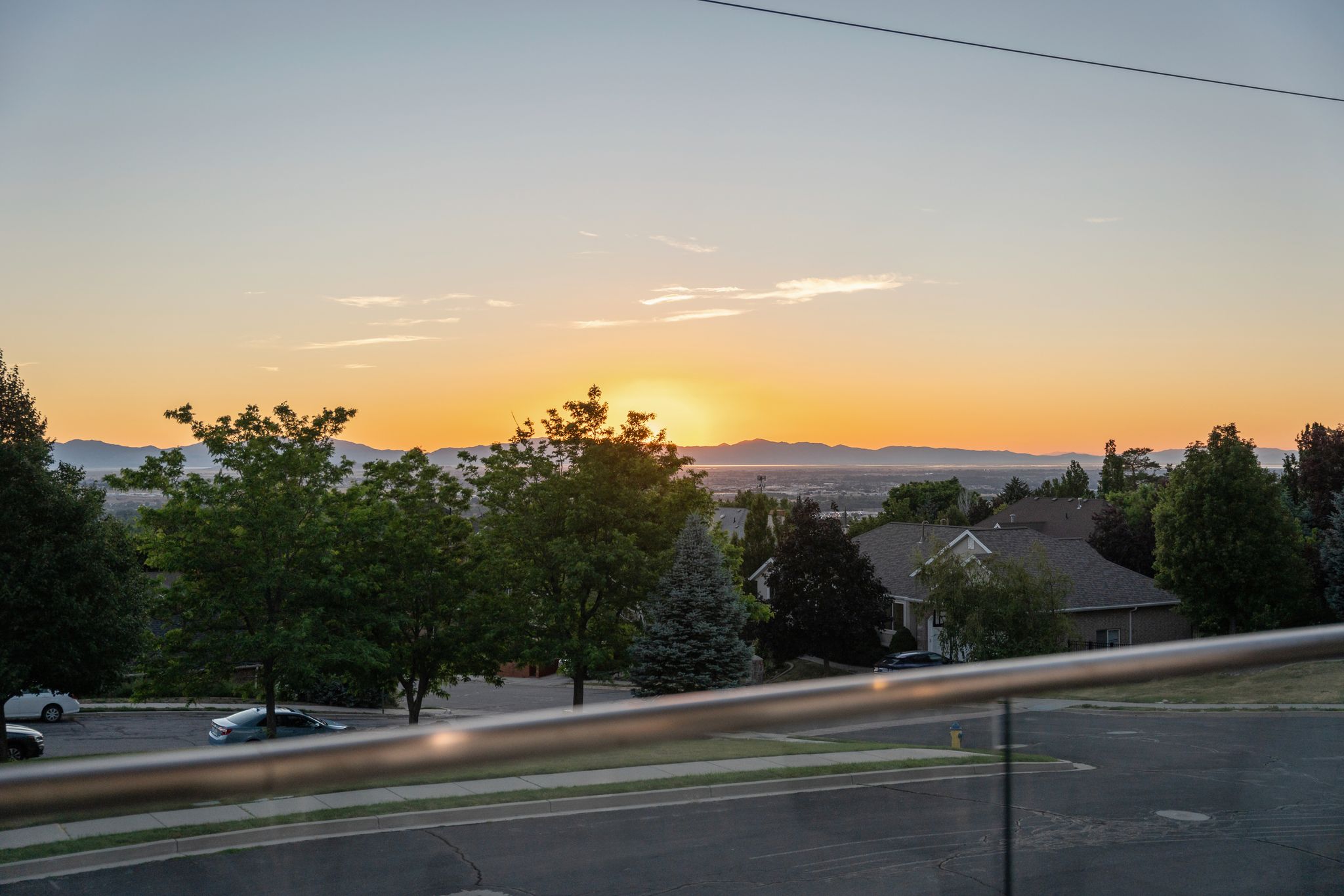 Expansive mountain and distant city scenery, featuring a vibrant sunset horizon