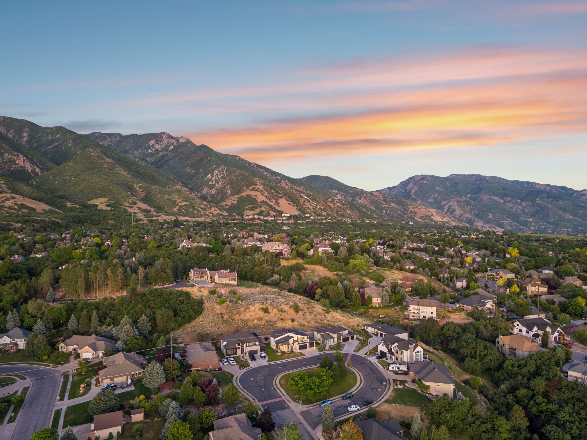 Expansive mountain landscape with residential properties nestled amongst abundant mature trees