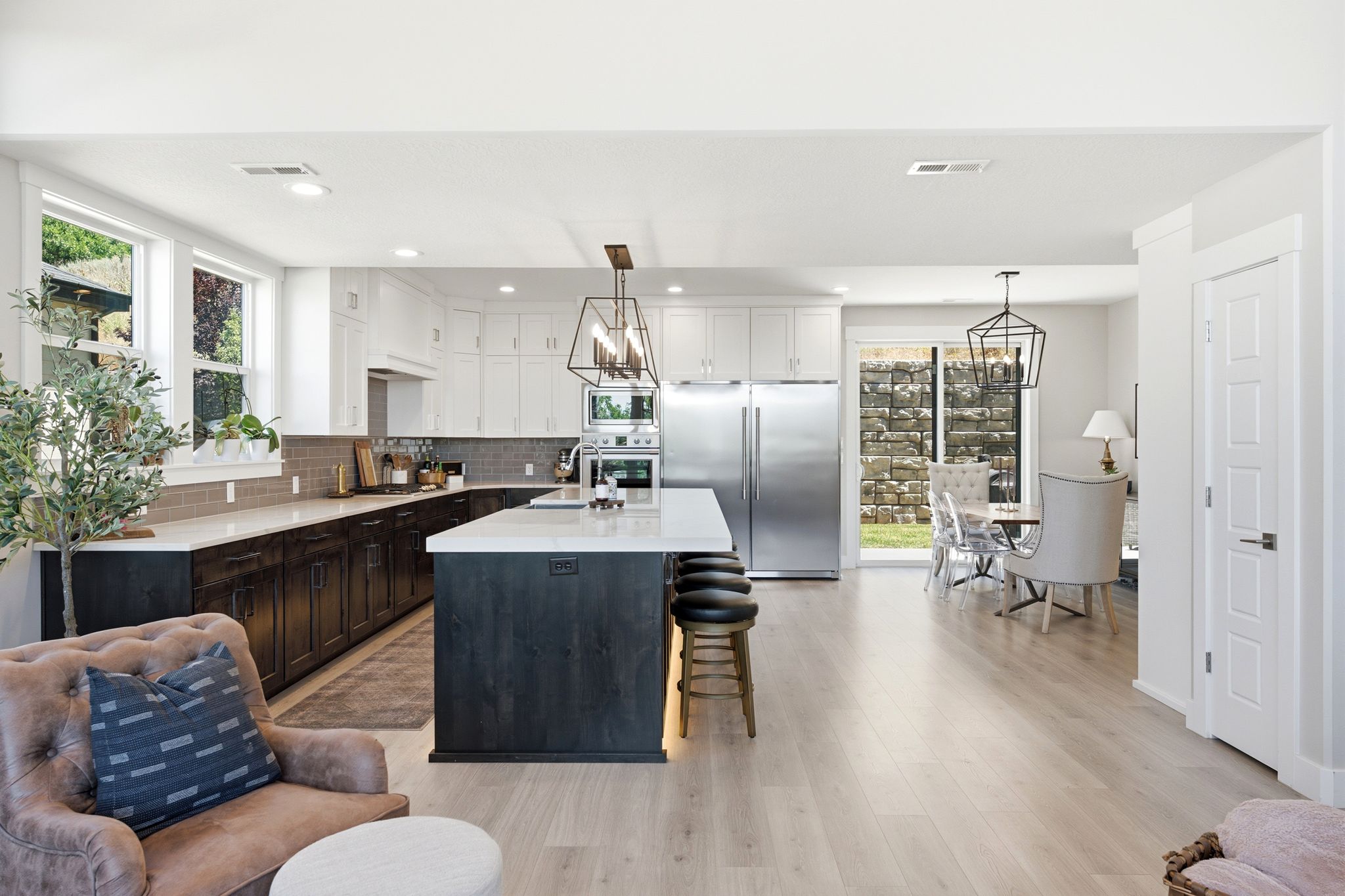 Open-concept living space featuring light wood-finish flooring, a contemporary kitchen, and a dining area
