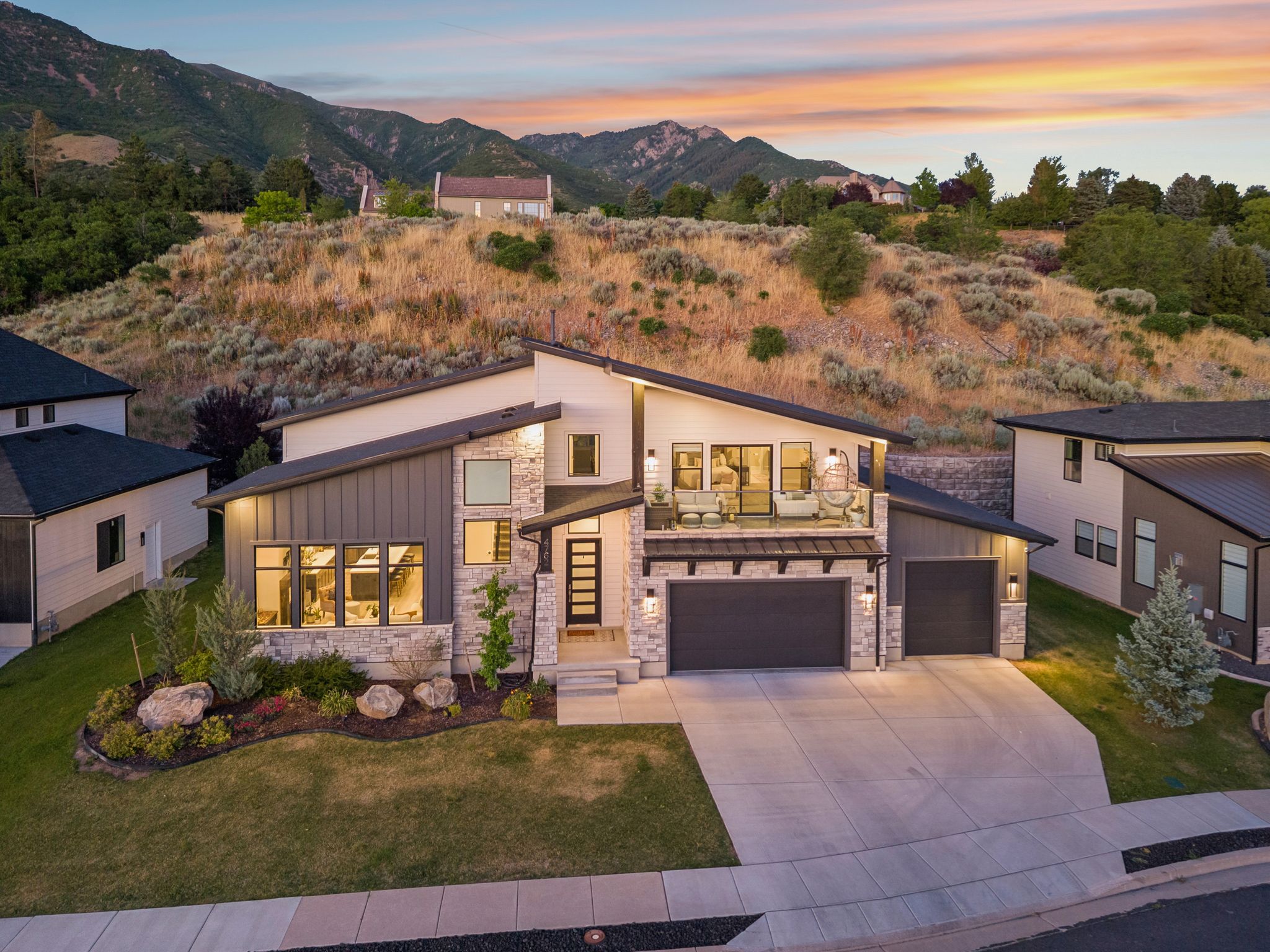 Modern architectural exterior featuring stone accents, vertical siding, and a multi-pitch roofline
