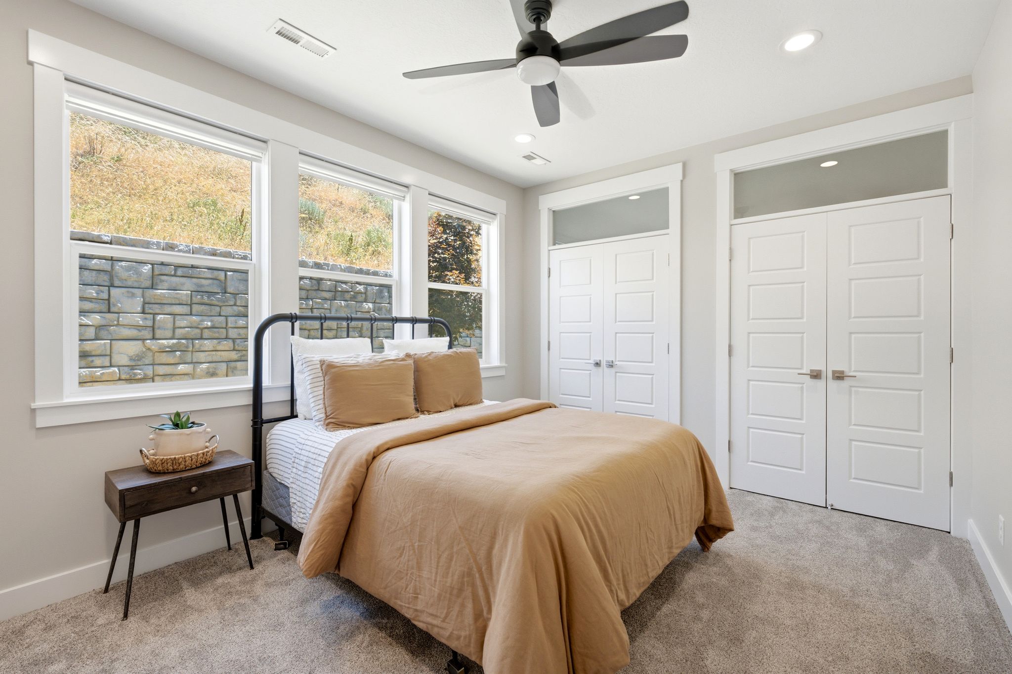 Carpeted room featuring a ceiling fan, recessed lighting, and three large windows with white trim