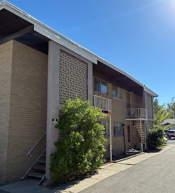 Brick exterior apartment building featuring decorative breezeblock panels and white balcony railings