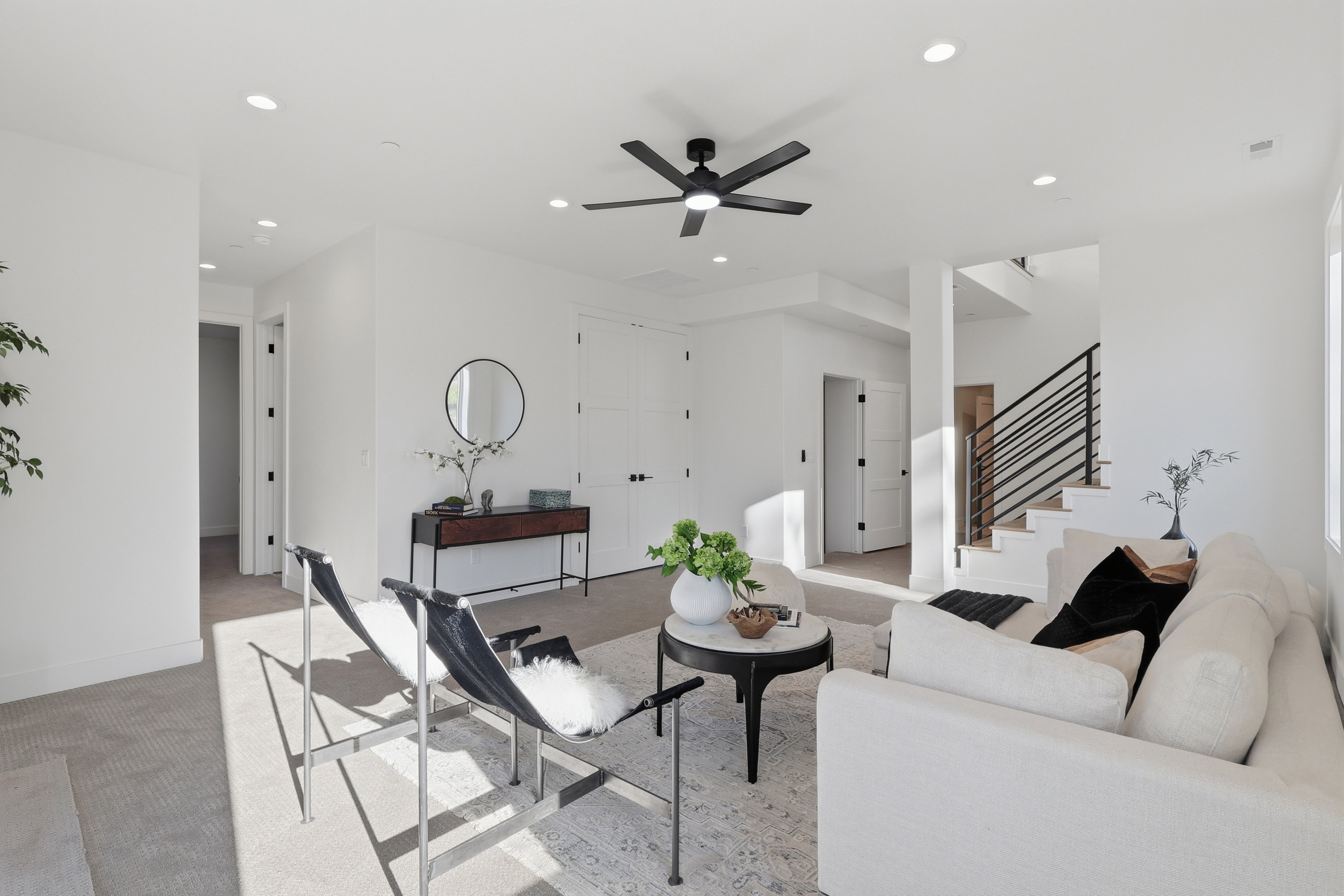 Contemporary living area with recessed lighting, a modern ceiling fan, and light-toned carpeting