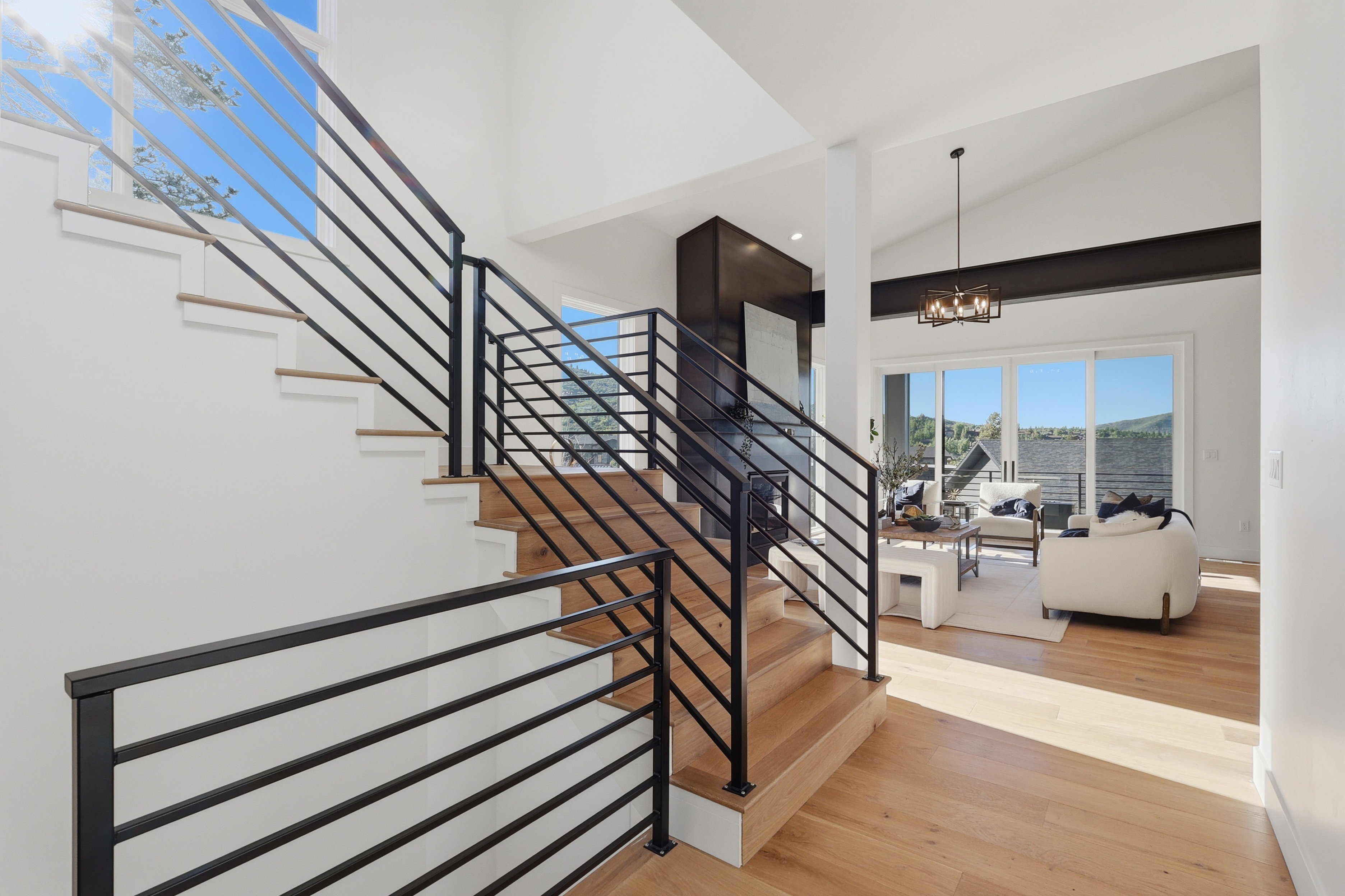 Modern staircase with black metal railings and natural wood-finish treads