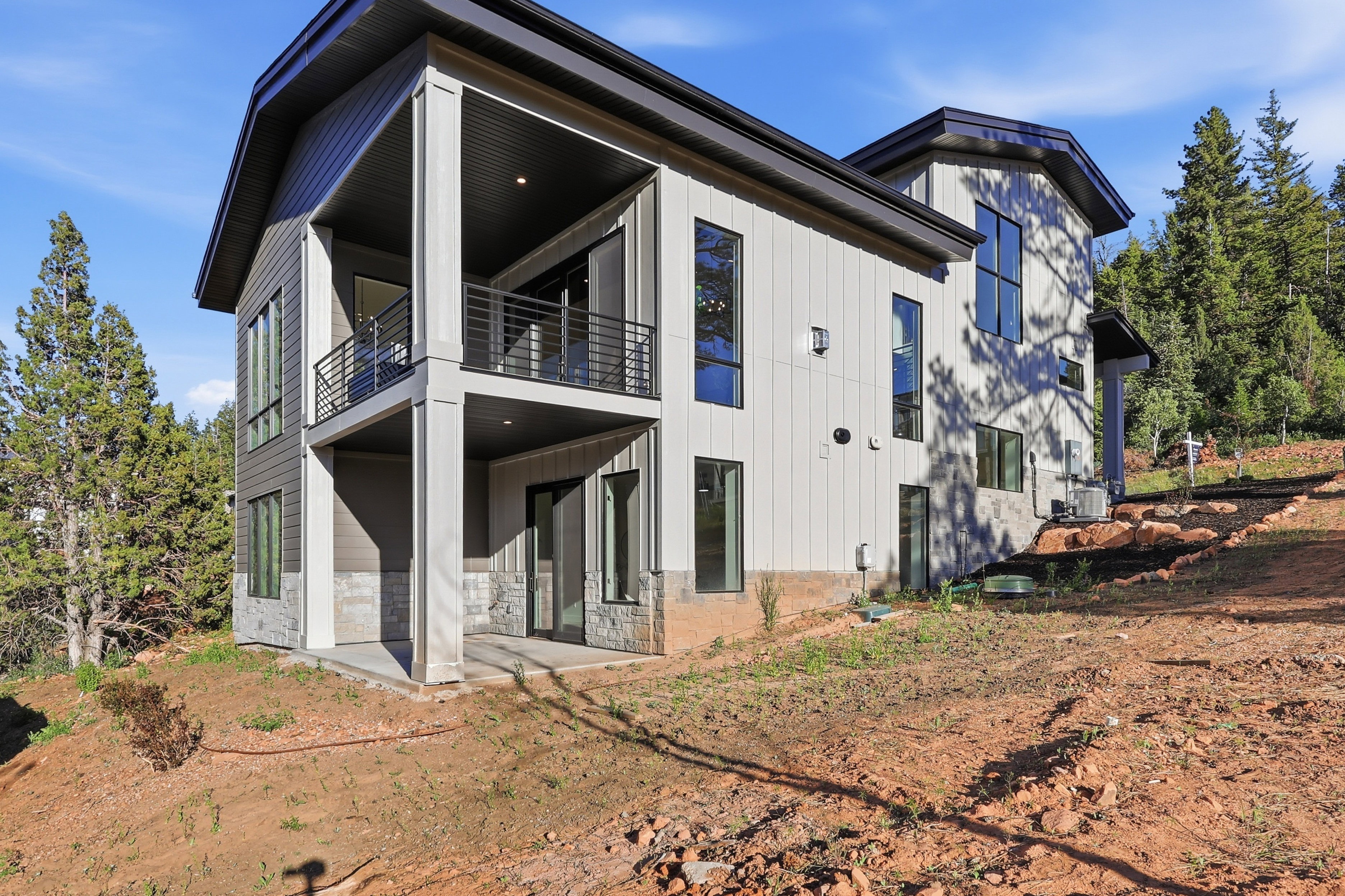 Contemporary multi-level residence featuring a dark-trim roofline and vertical siding