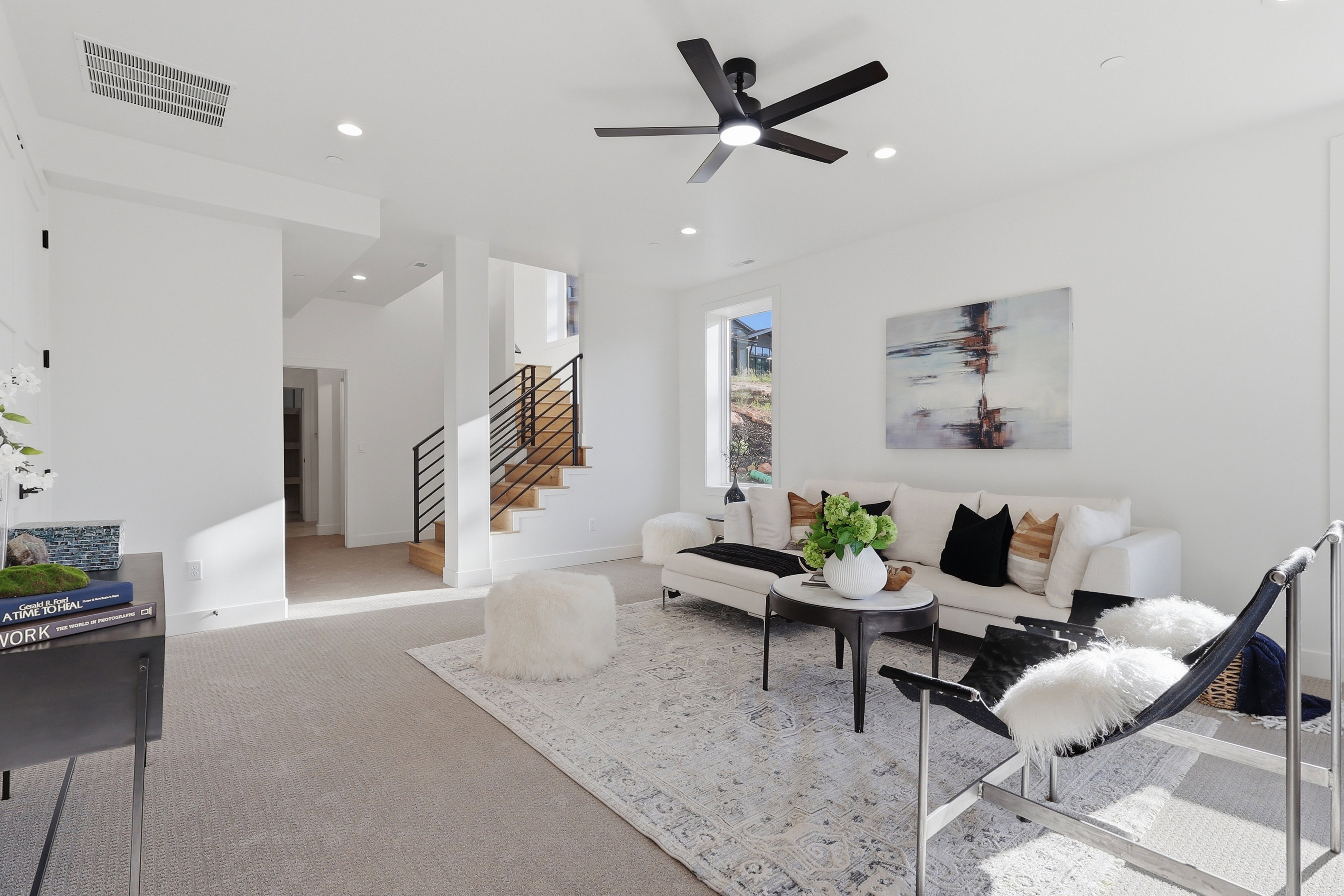 Living area featuring recessed lighting and a black ceiling fan