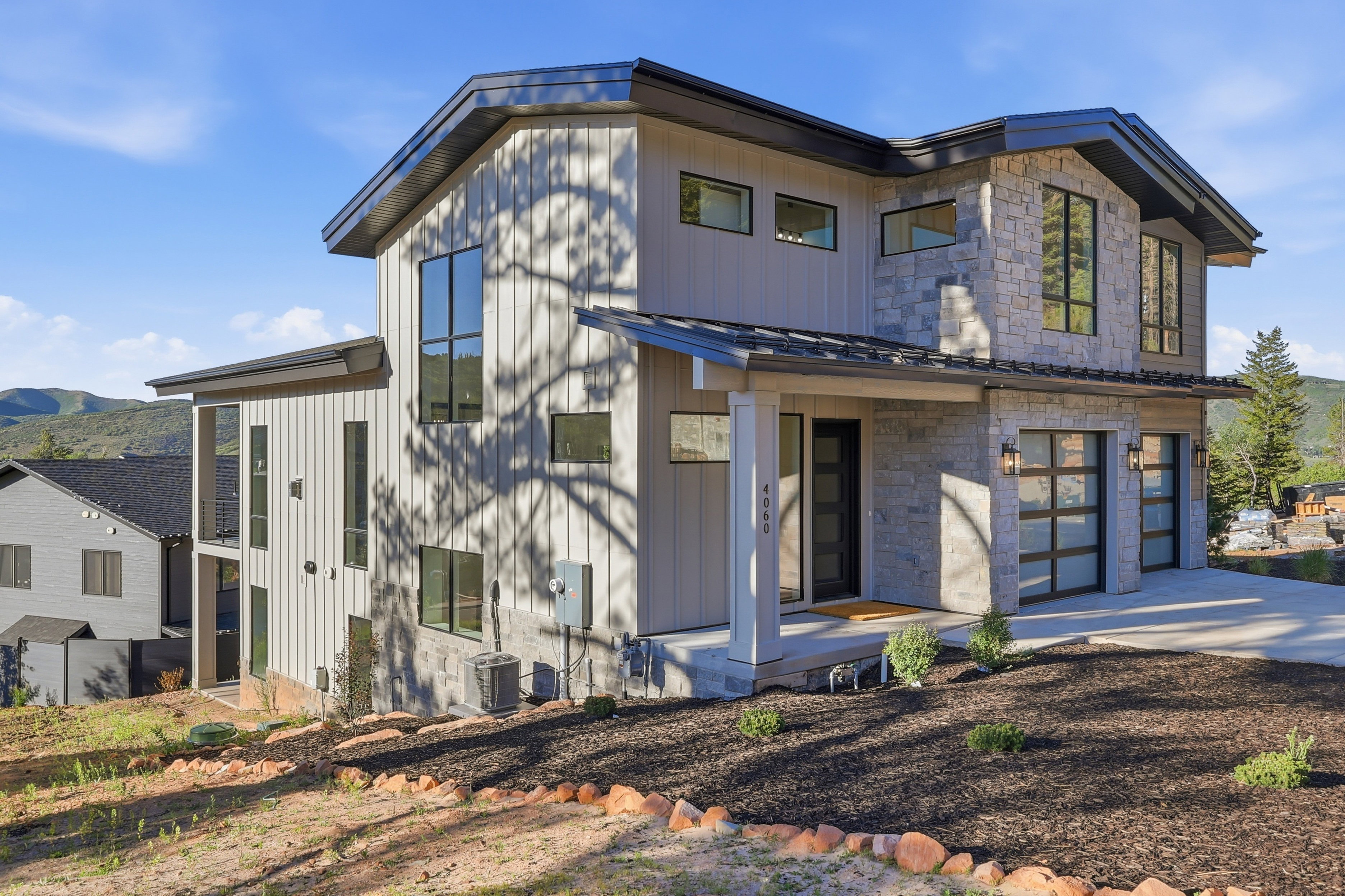 Contemporary residence featuring vertical siding and stone veneer accents