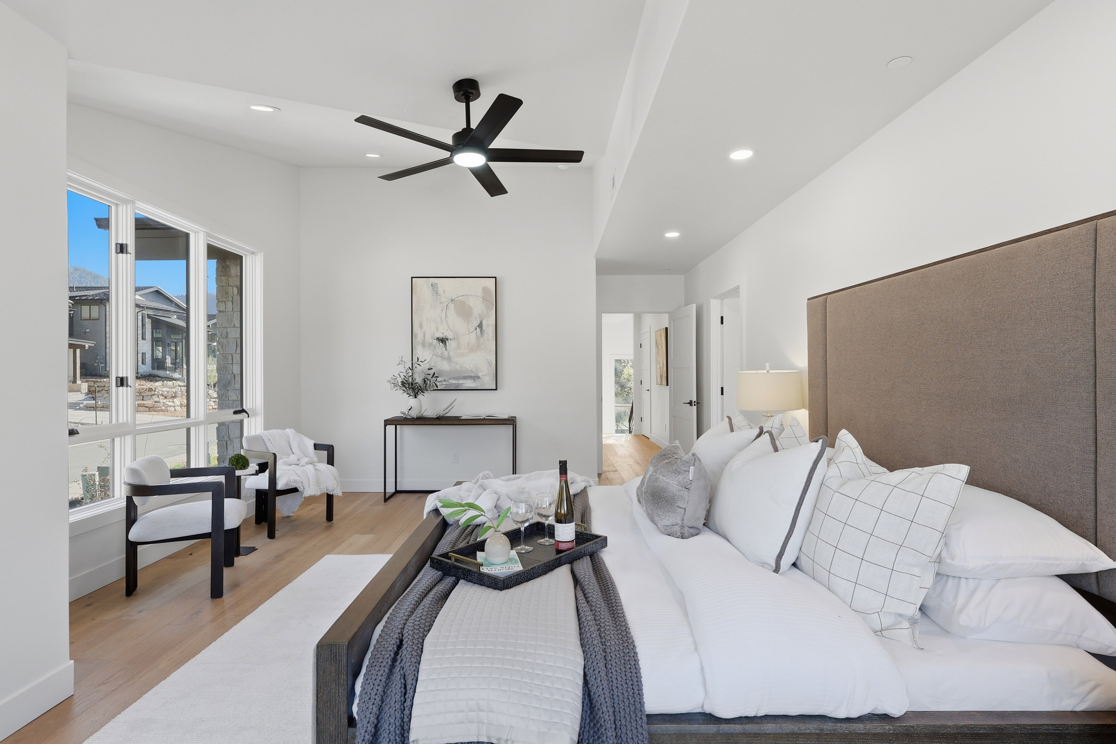 Spacious room with light wood-finish flooring and ample natural light from large windows
