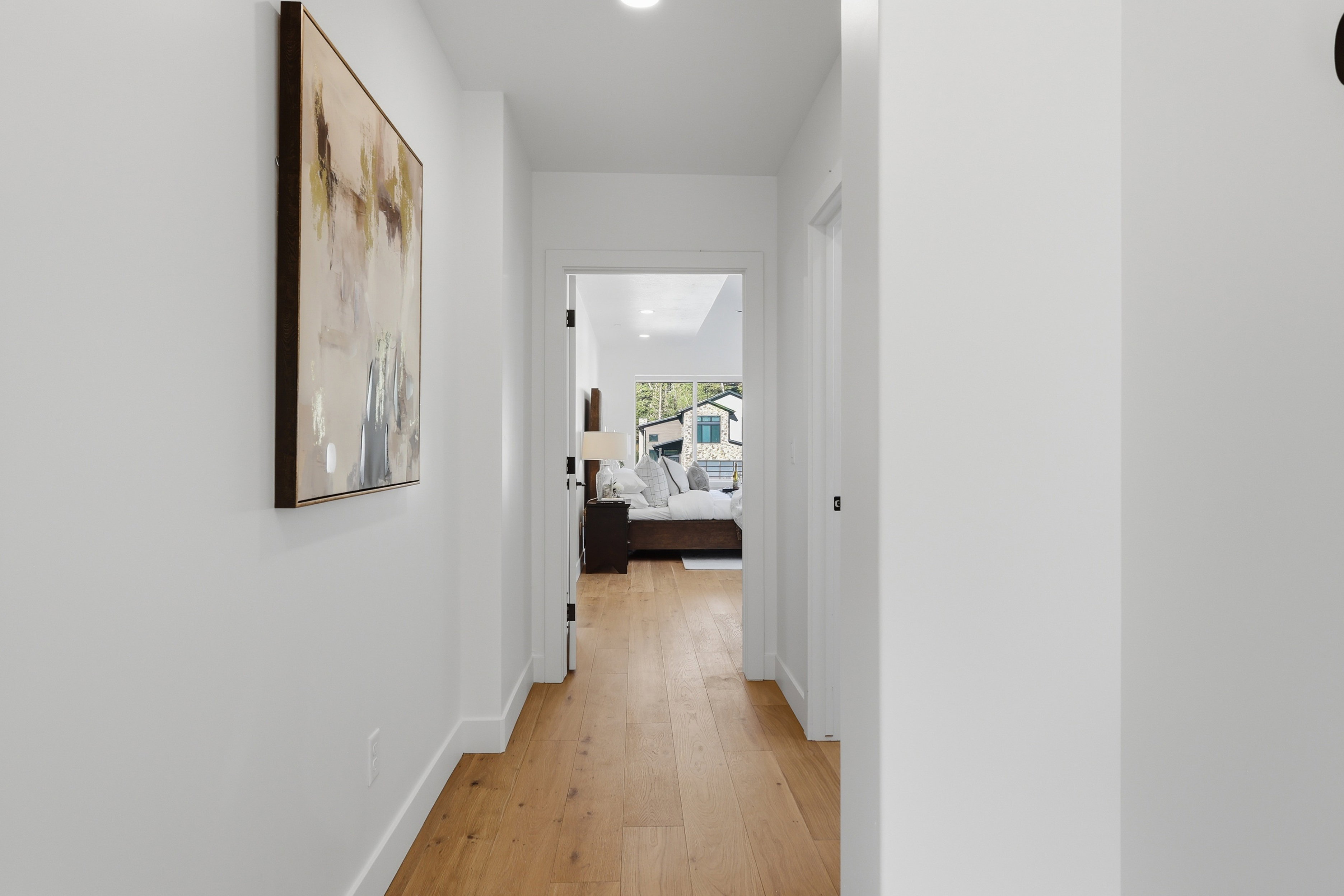 Hallway featuring light wood-finish flooring, white baseboards, and recessed lighting