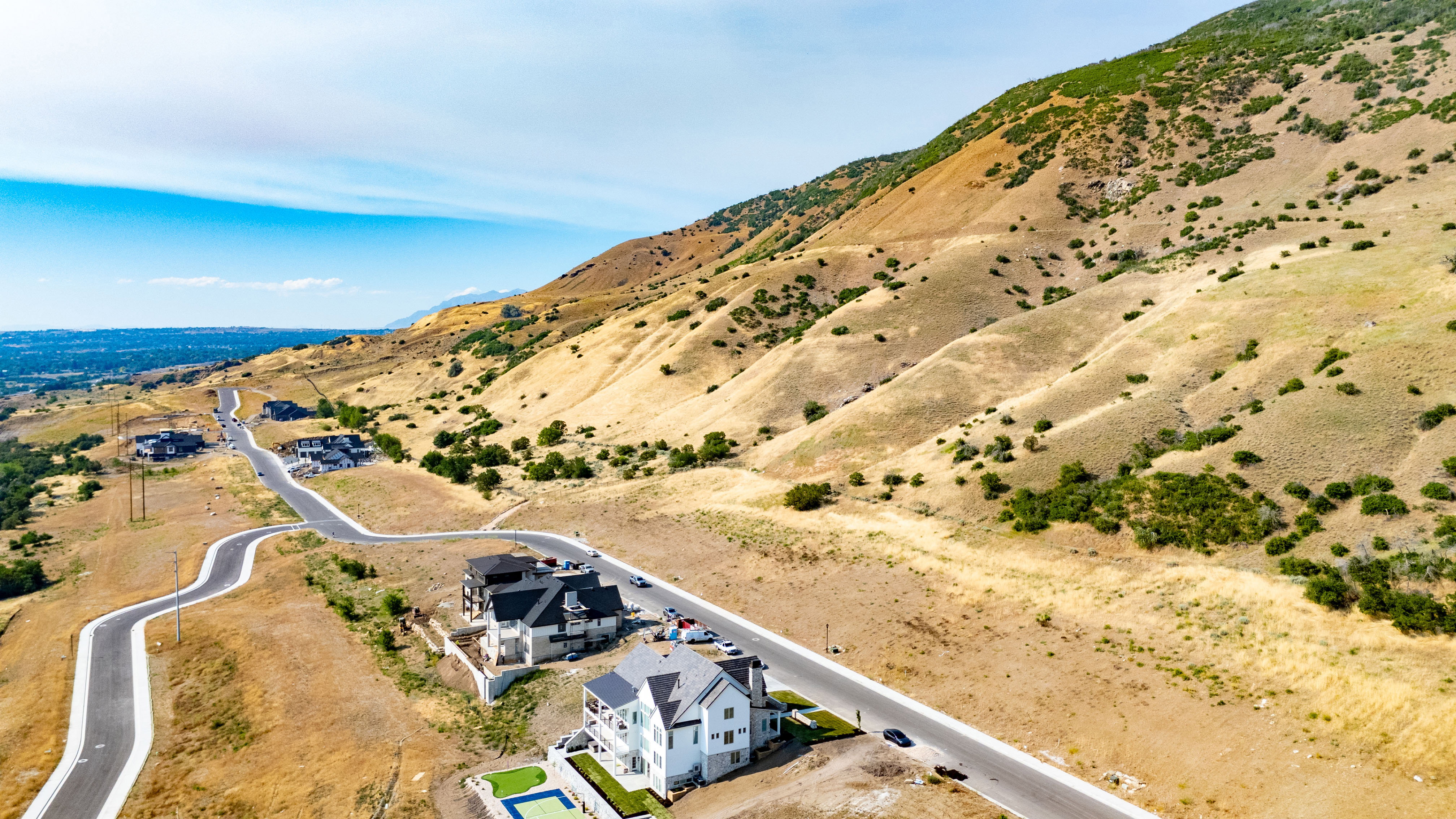 Expansive hillside development featuring multiple residential properties and paved roads