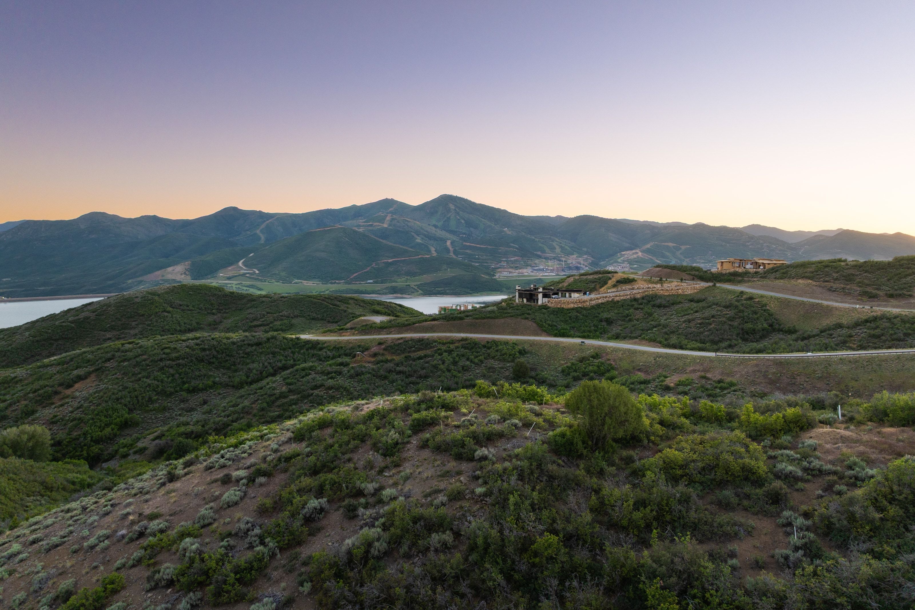 Expansive undeveloped land featuring rolling hills and distant mountainous terrain