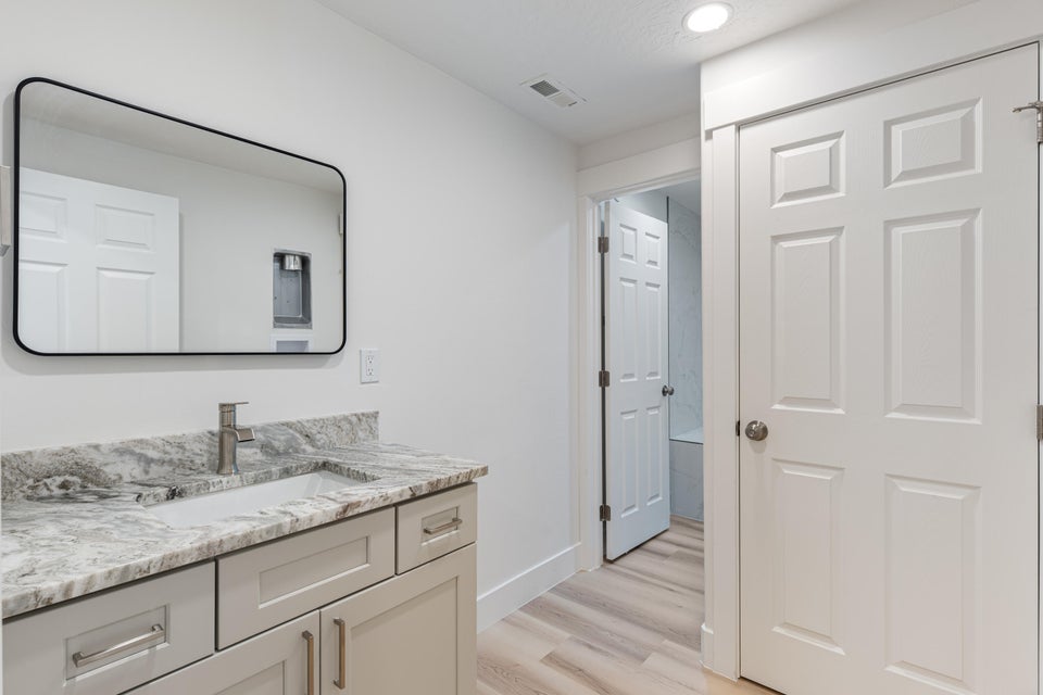 Vanity featuring a stone countertop, an undermount sink, and a single-handle faucet