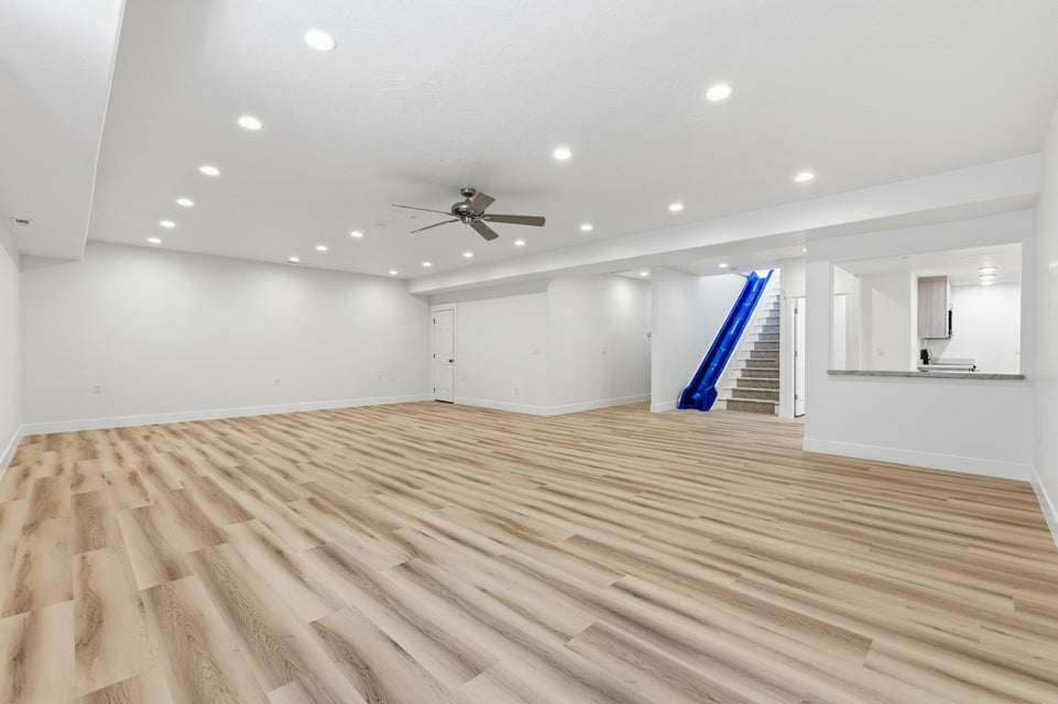 Spacious recreation room featuring wood-finish flooring and extensive recessed lighting