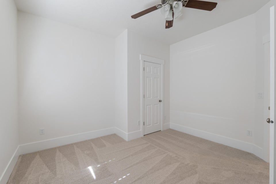 Neutral tone carpet with white baseboards and walls