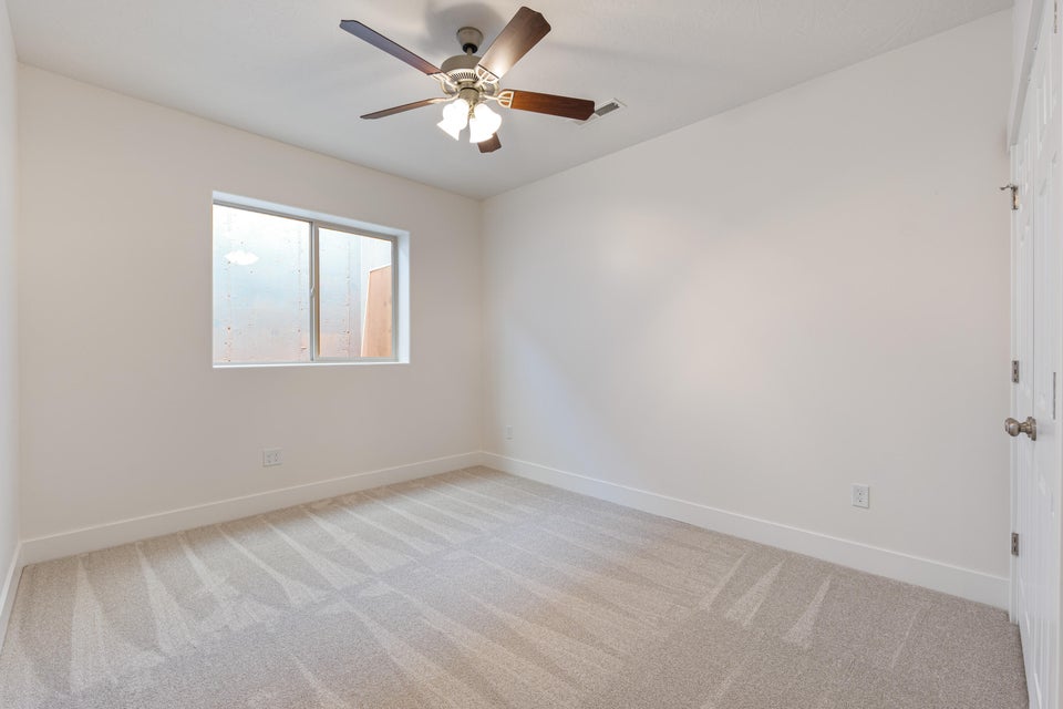 Neutral-toned carpet flooring with white baseboards throughout