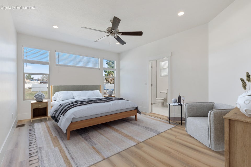 Spacious bedroom featuring wood-finish flooring, recessed lighting, and a ceiling fan