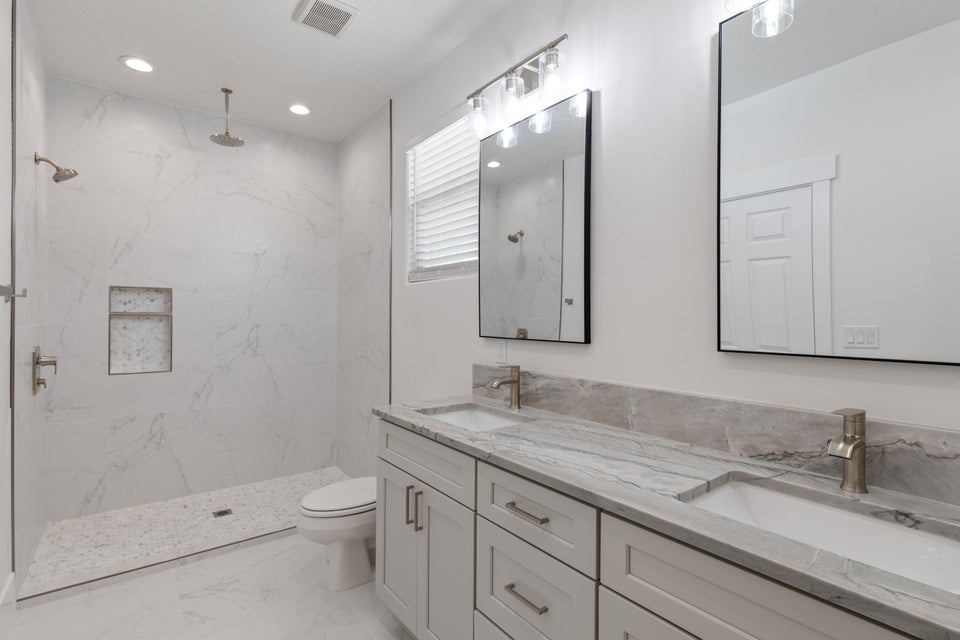 Contemporary bathroom featuring a spacious walk-in shower with a rain shower head and a tiled niche