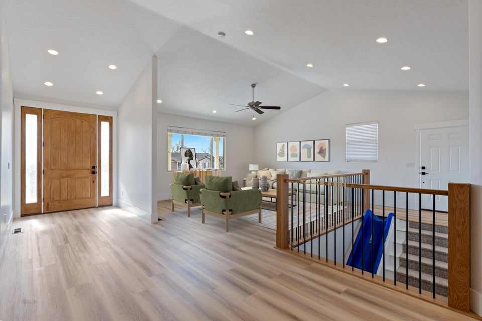Entryway featuring a natural wood front door with sidelights, wood-finish flooring, recessed lighting, and vaulted ceilings