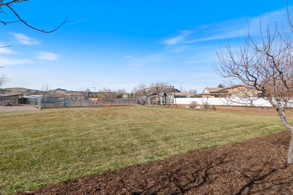 Expansive grassy yard with a mulched border and distant mountain backdrop