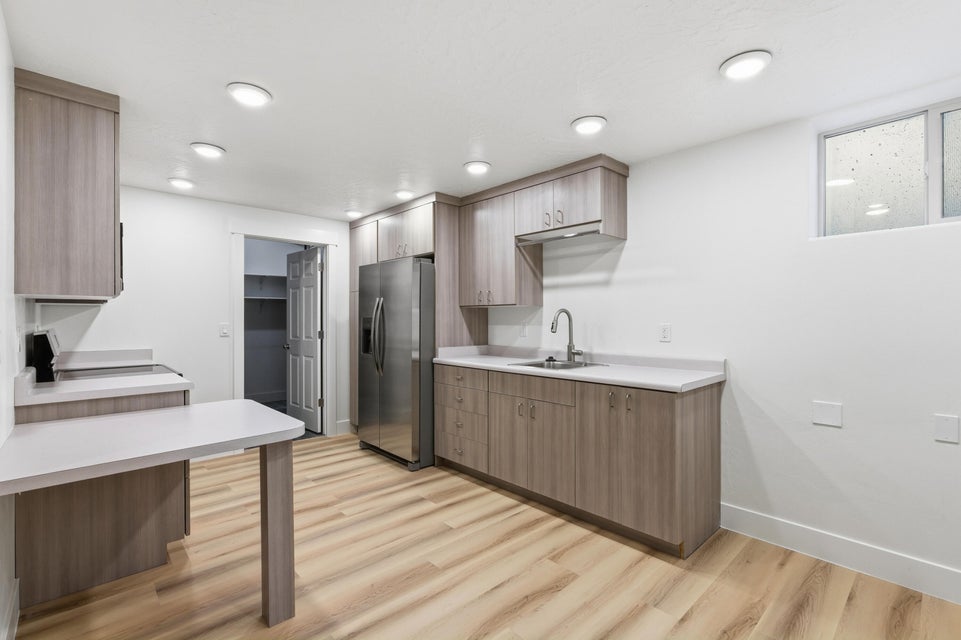 Kitchen featuring wood-finish cabinetry, light countertops, stainless steel appliances, and recessed lighting