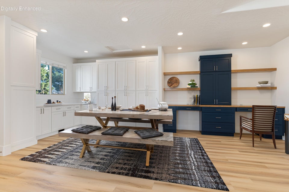 Spacious kitchen area featuring extensive white cabinetry, light wood-finish flooring, and recessed lighting