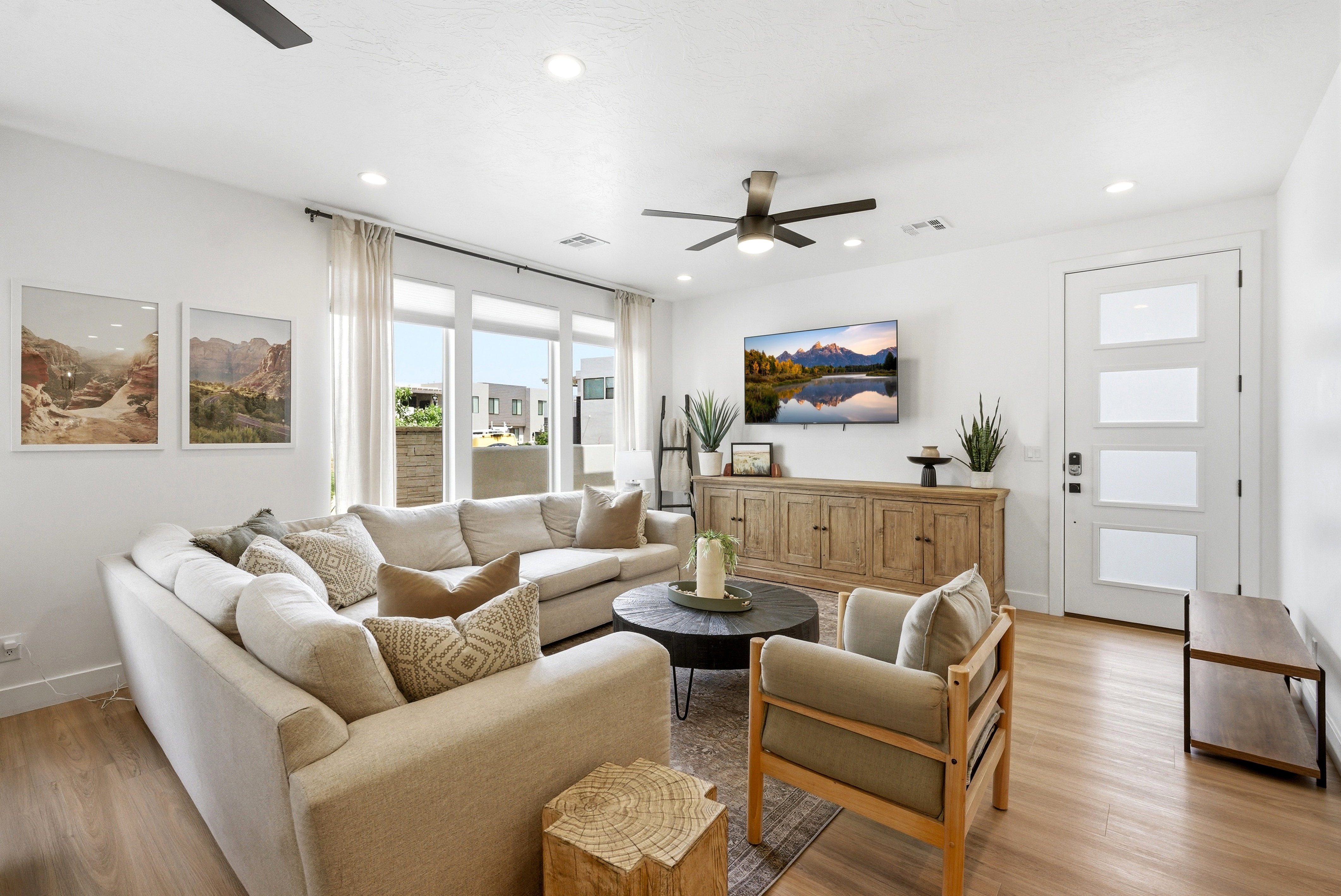 Spacious open-concept living area featuring wood-finish flooring, recessed lighting, and a modern ceiling fan