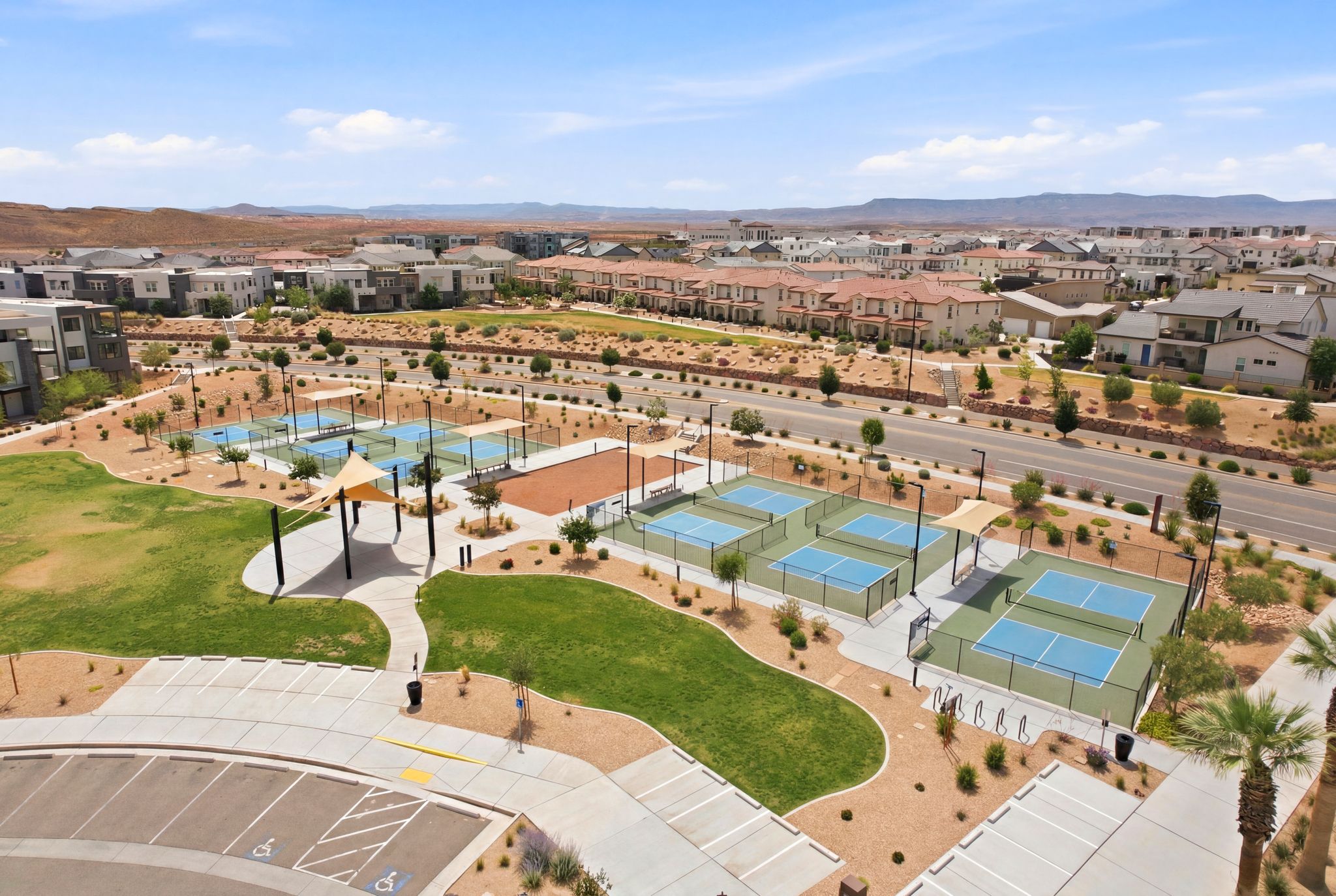 Community park featuring multiple pickleball courts, grassy recreation areas, and shaded gathering spaces