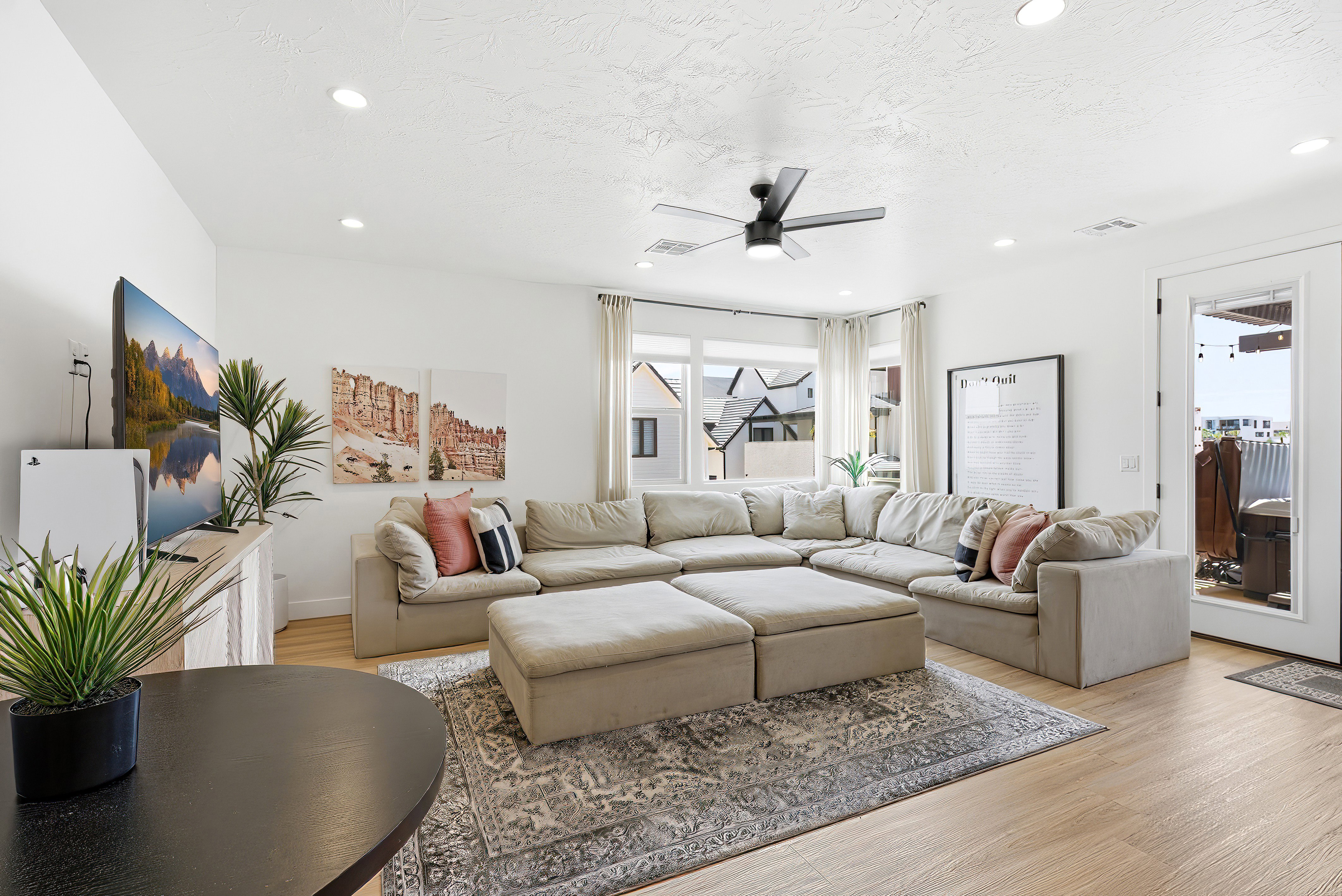 Open-concept living space with light wood-finish flooring, recessed lighting, and a contemporary ceiling fan