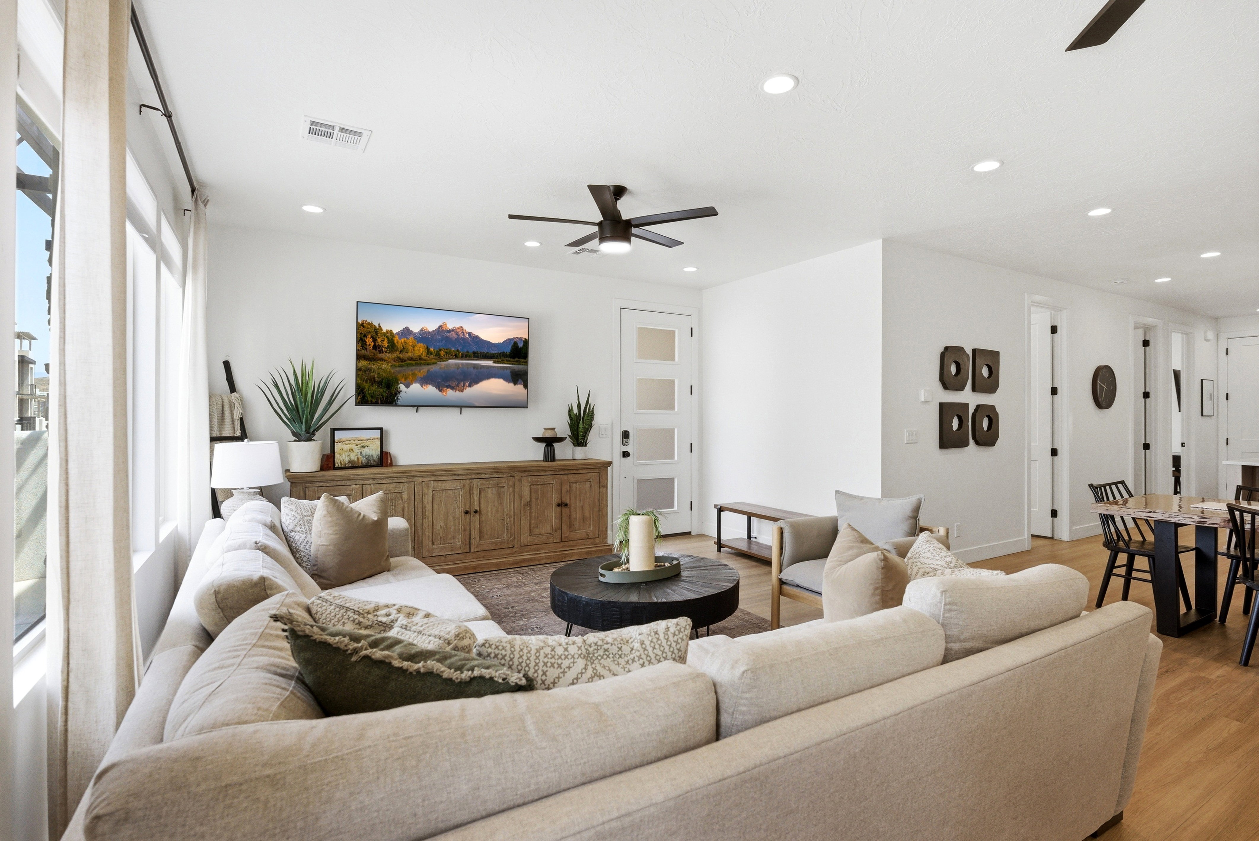 Open-concept living area featuring light wood-finish flooring, recessed lighting, and a contemporary ceiling fan