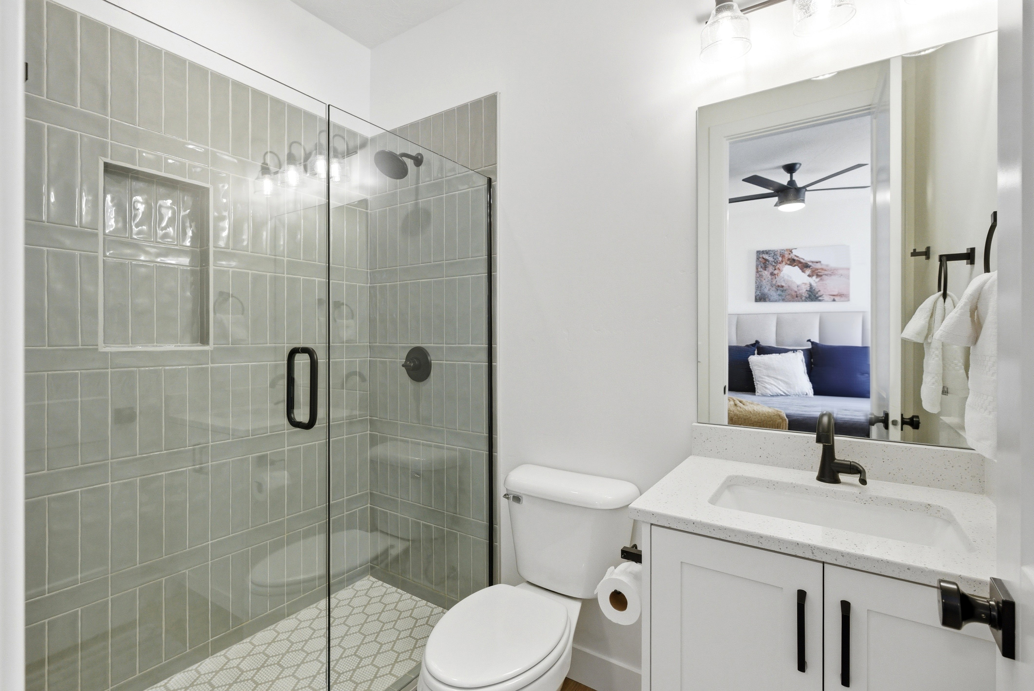 Contemporary bathroom featuring a glass-enclosed shower with subway tile surround and integrated niche