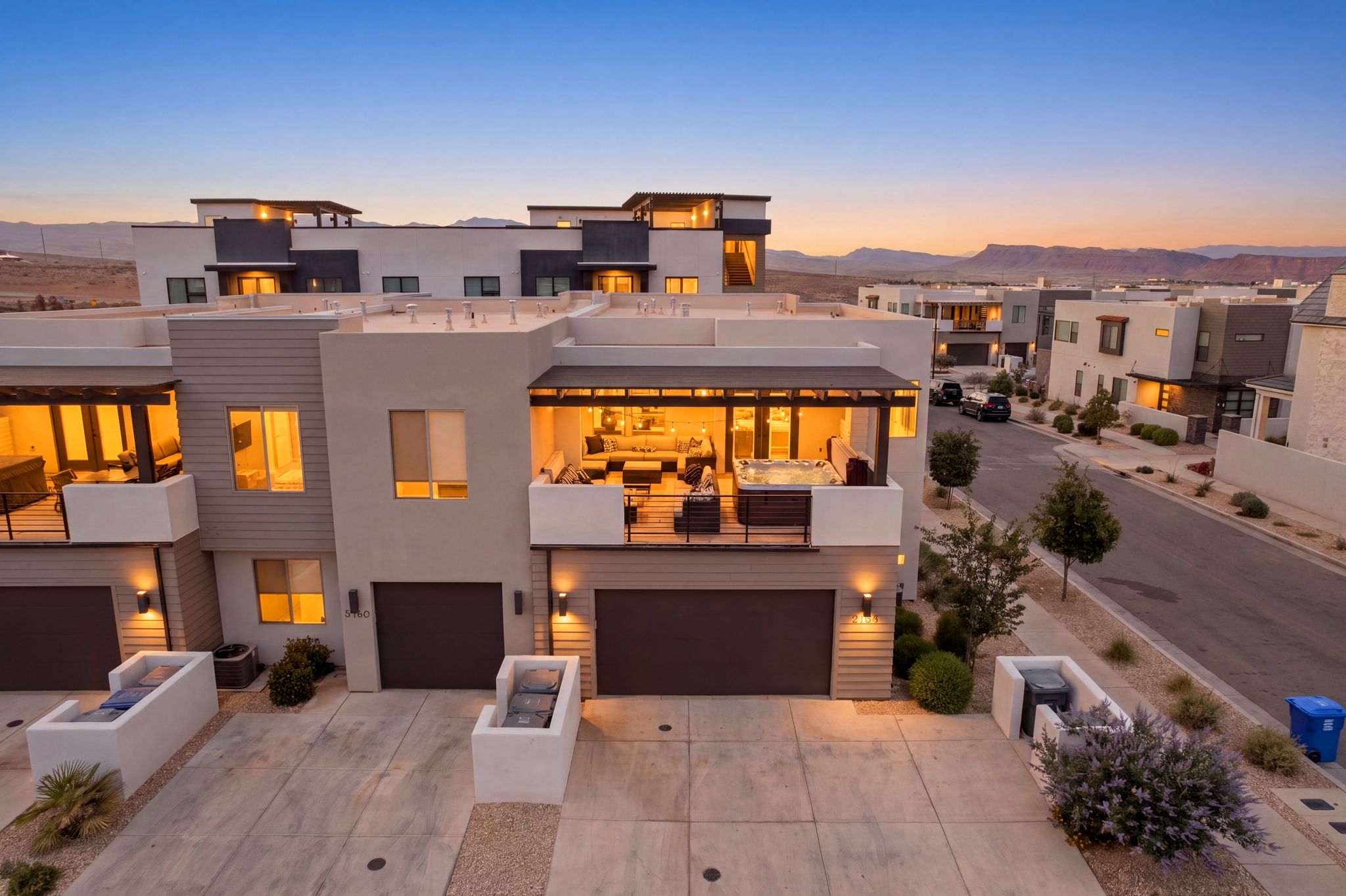 Contemporary multi-story residence featuring a flat roofline and a private upper-level balcony with a hot tub