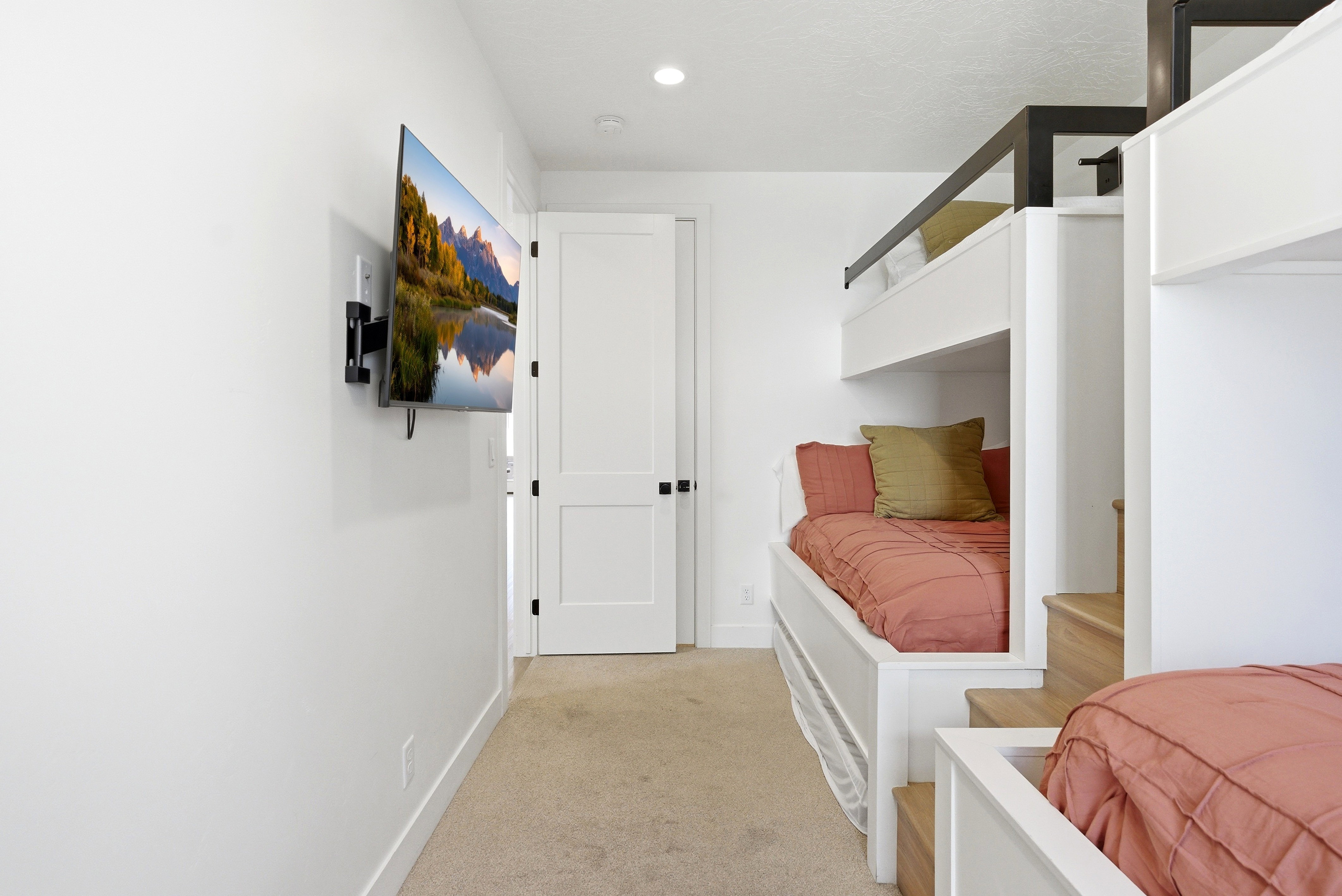 Built-in bunk beds with integrated wood-finish steps and black metal railings