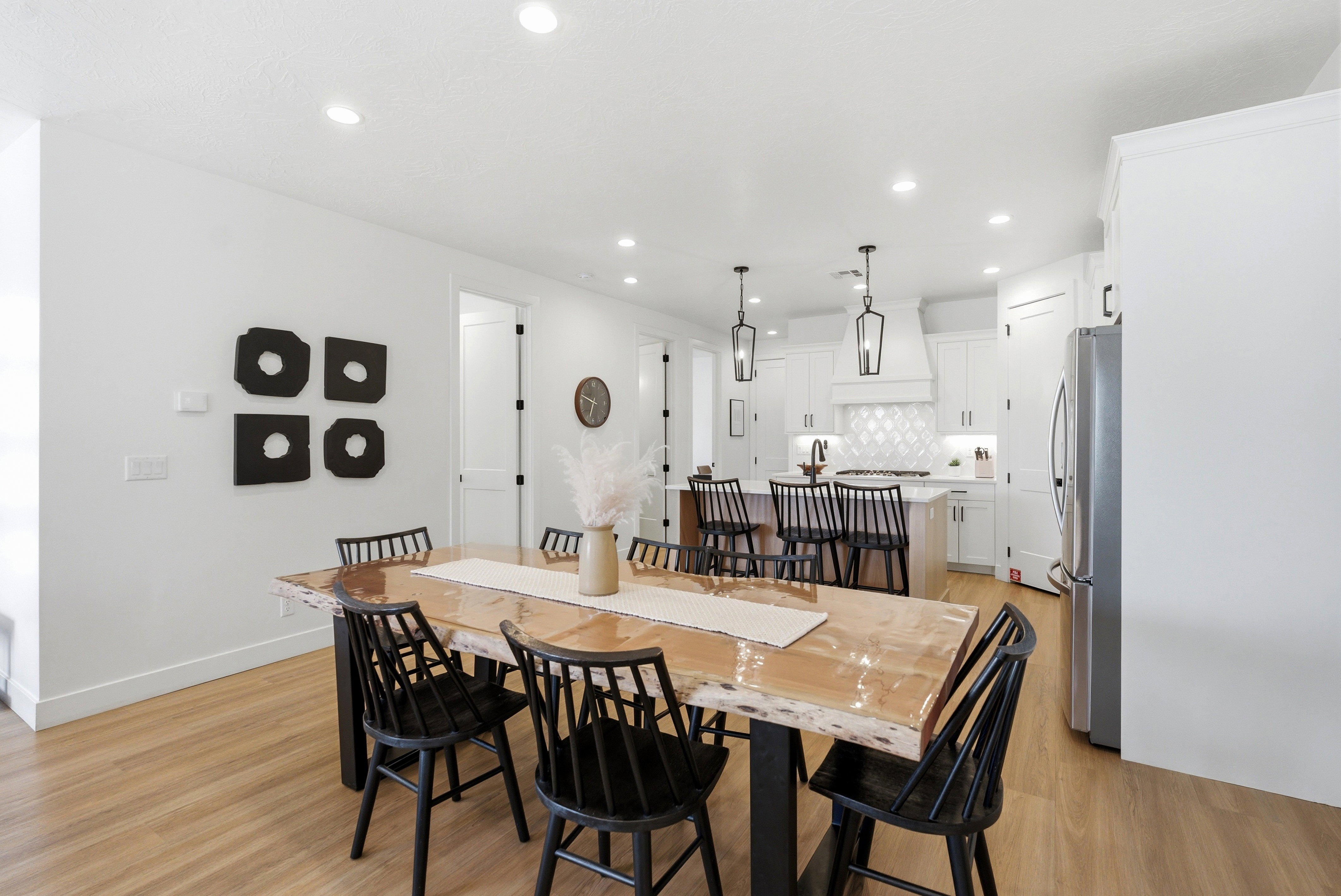 Open-concept dining area featuring wood-finish flooring, recessed lighting, and a white color palette