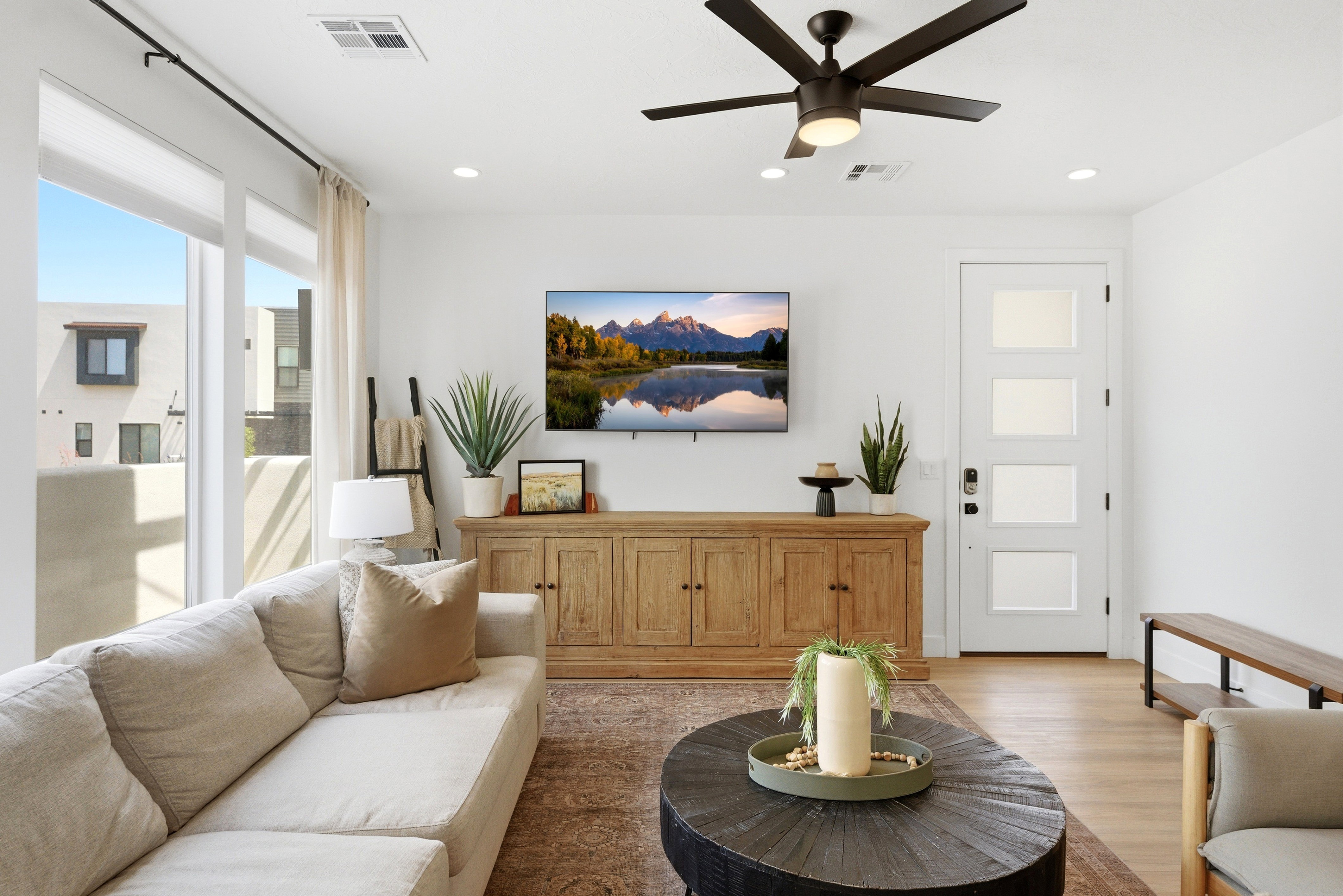 Bright living area featuring wood-finish flooring and a contemporary black ceiling fan