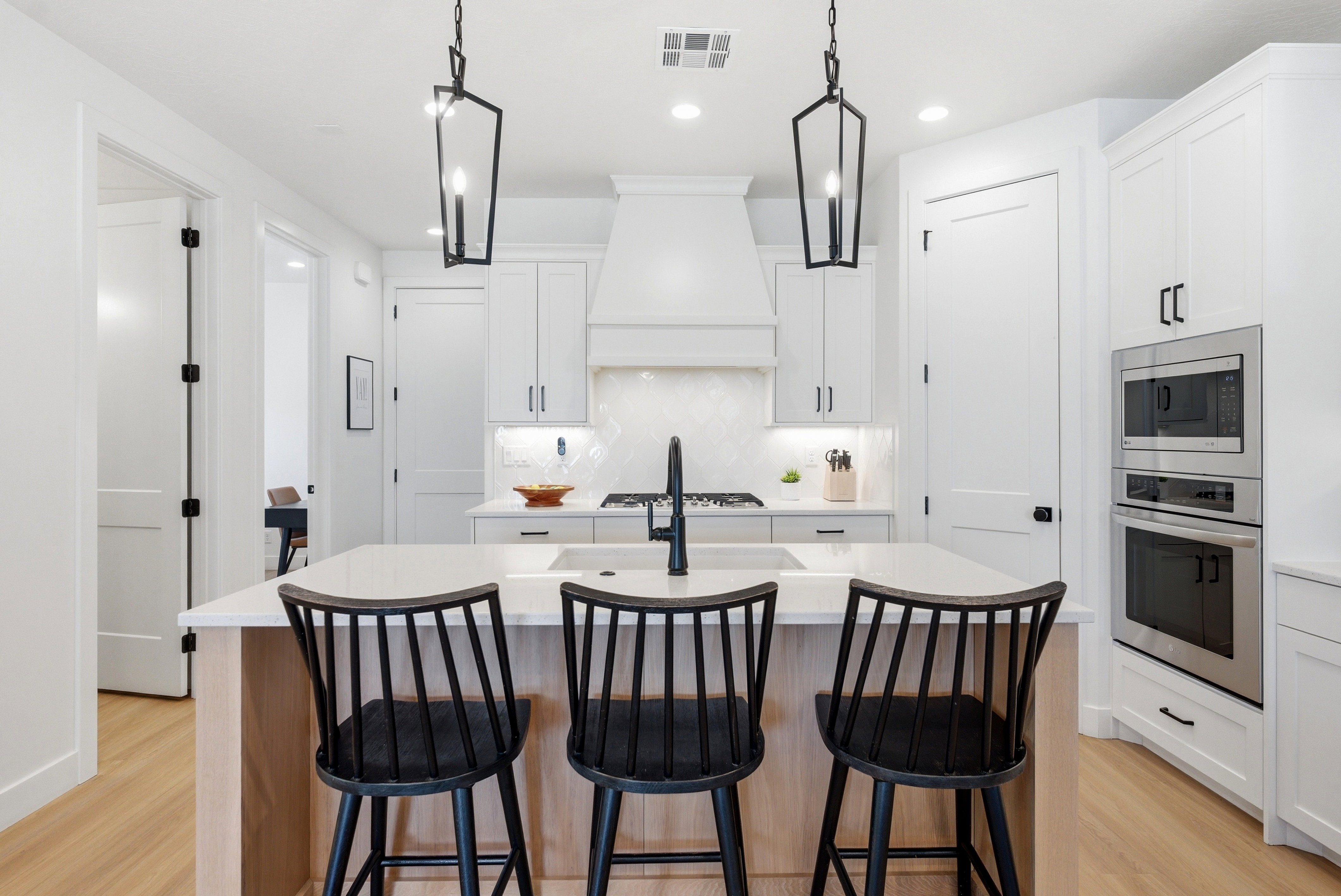 Modern kitchen featuring an expansive island with wood-finish paneling and a light-toned countertop