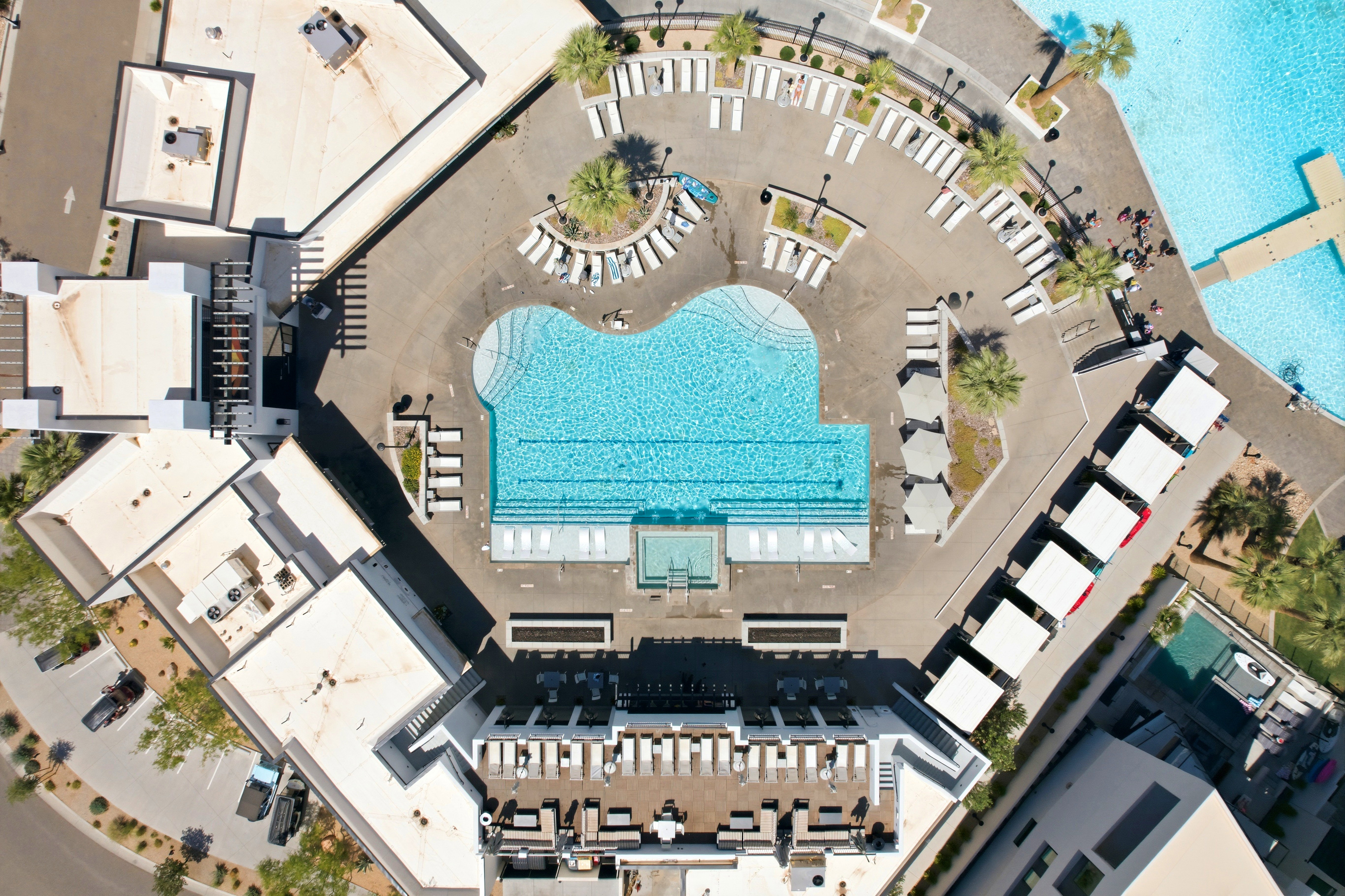 Expansive outdoor amenity area featuring a large, irregularly shaped swimming pool with integrated tanning ledges
