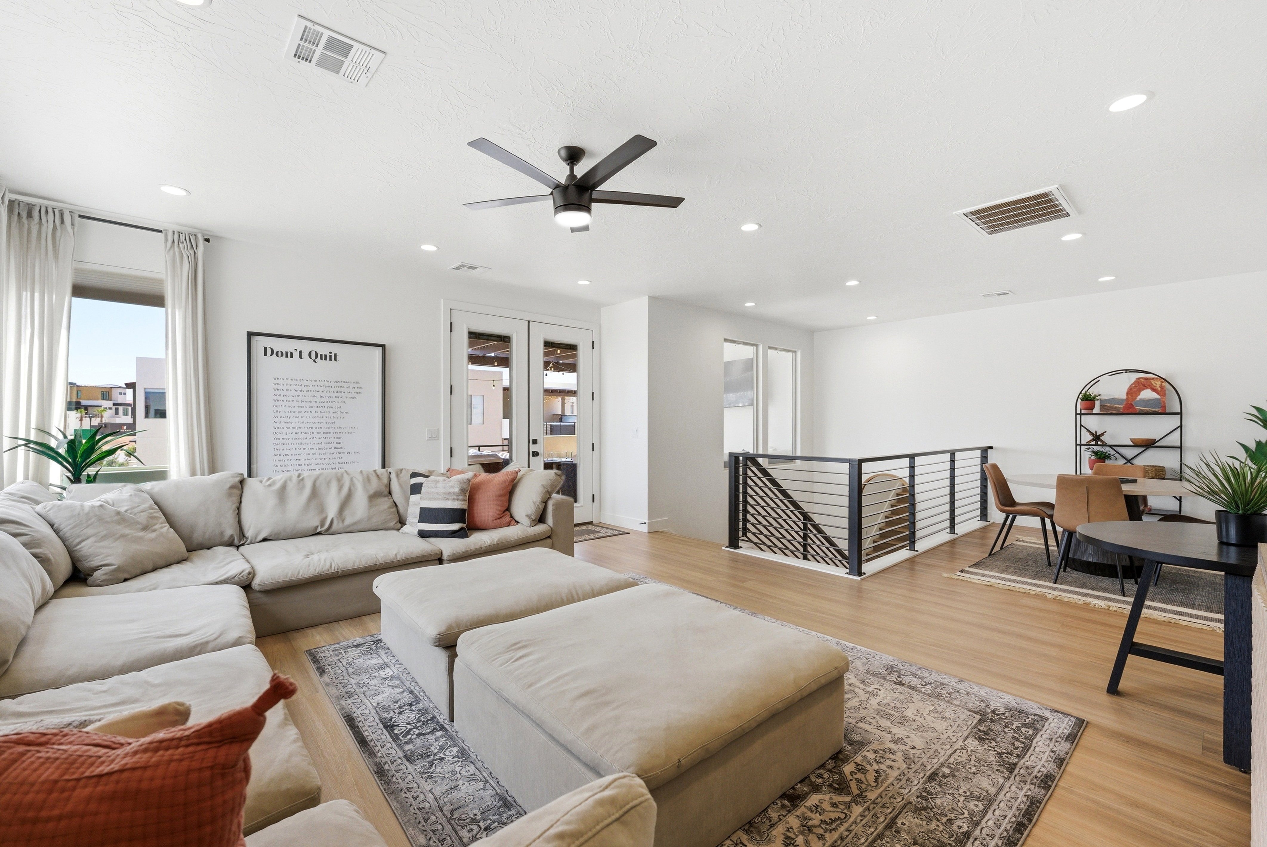 Open-concept living space featuring wood-finish flooring, recessed lighting, and a modern ceiling fan