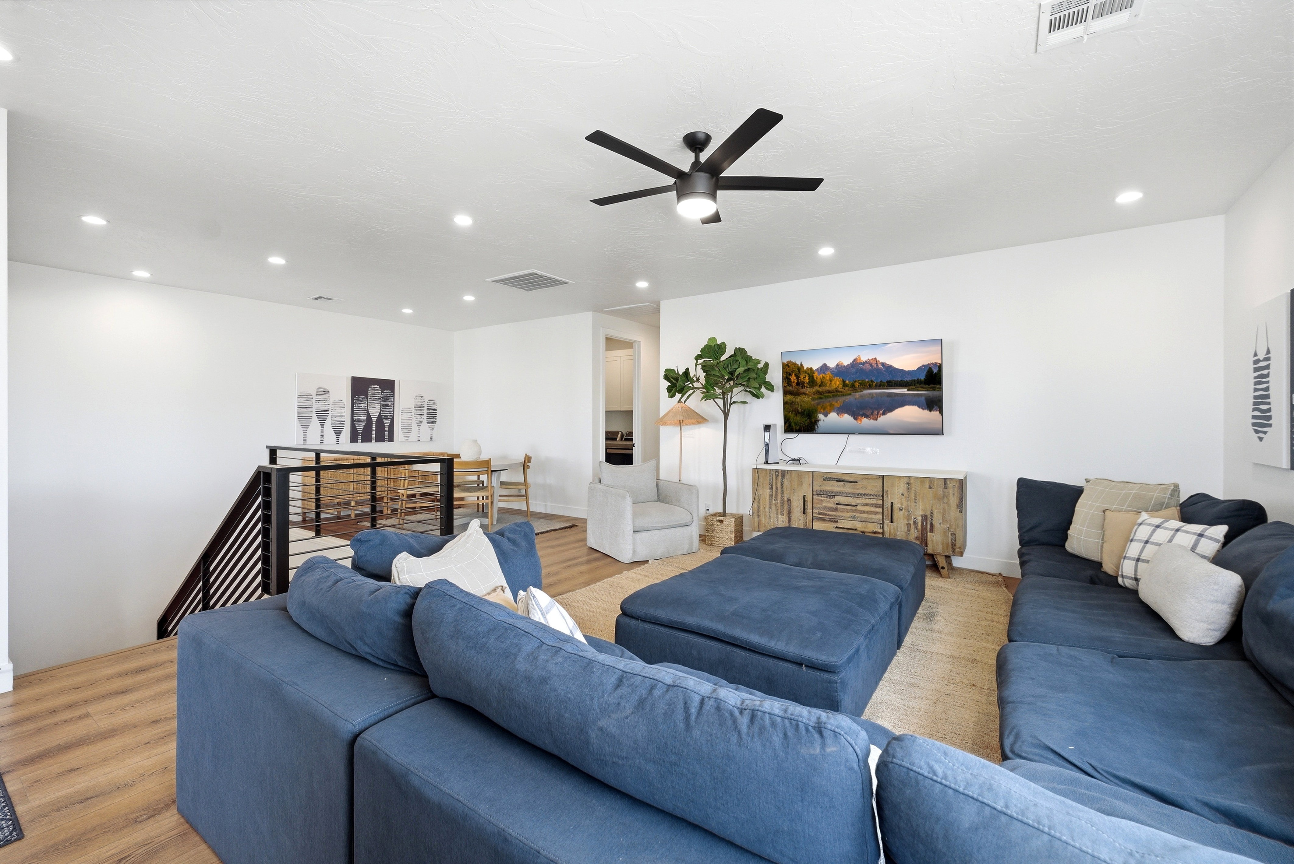 Open-concept living space featuring wood-finish flooring and a white wall finish
