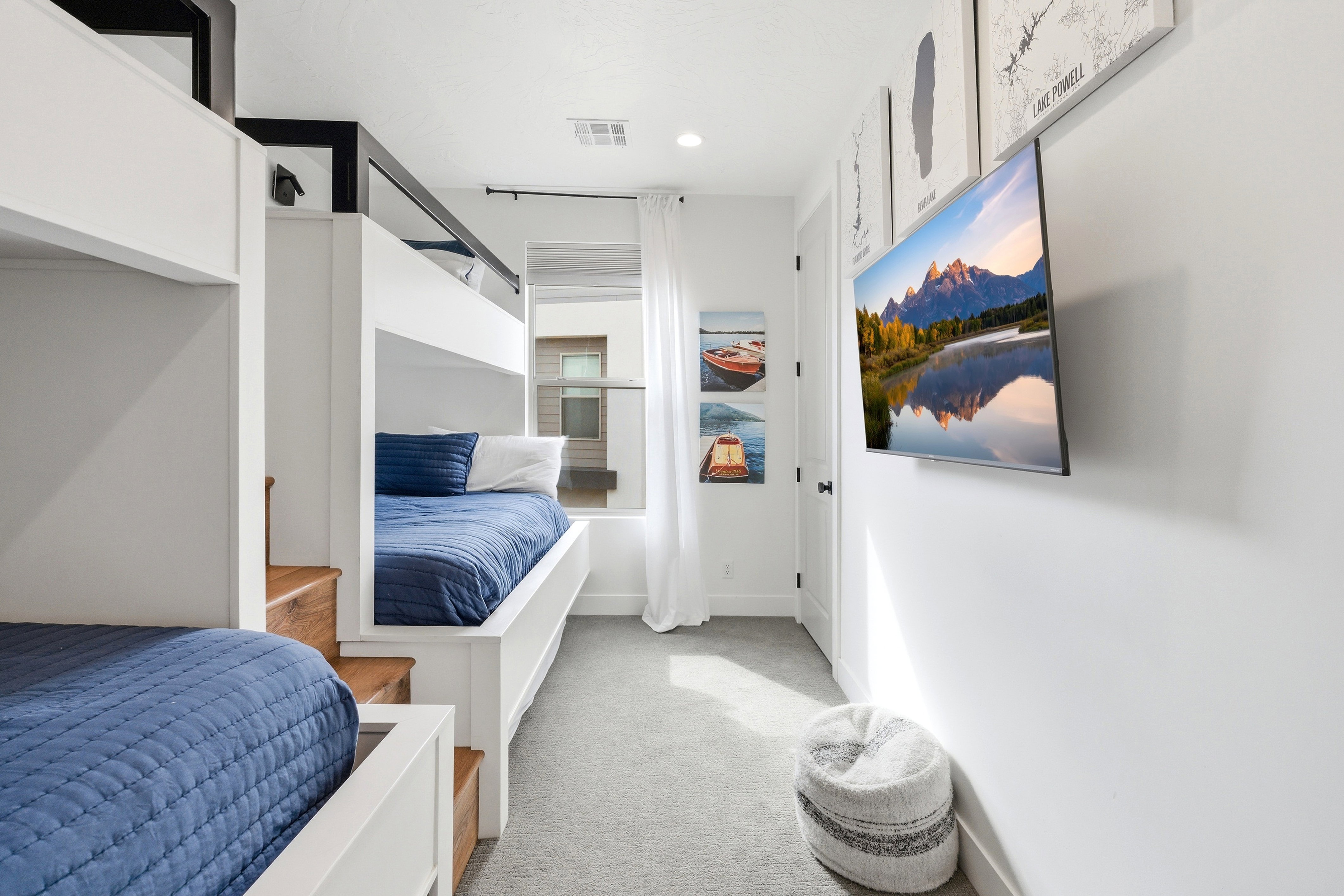 Room featuring built-in bunk beds with integrated wood-finish steps and a mounted television