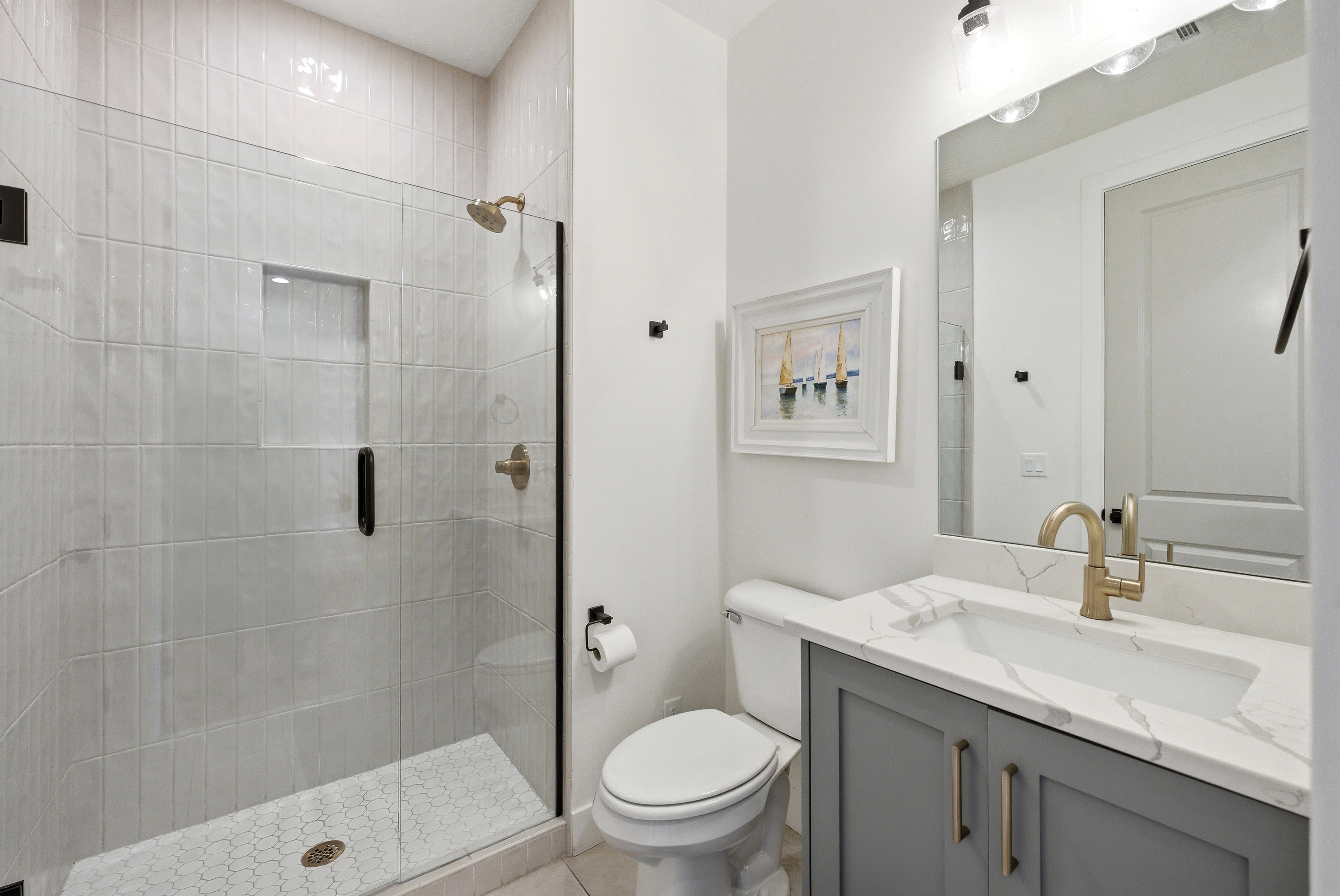 Bathroom featuring a glass-enclosed shower with vertical subway tile, an integrated shower niche, and a hexagonal mosaic tile floor