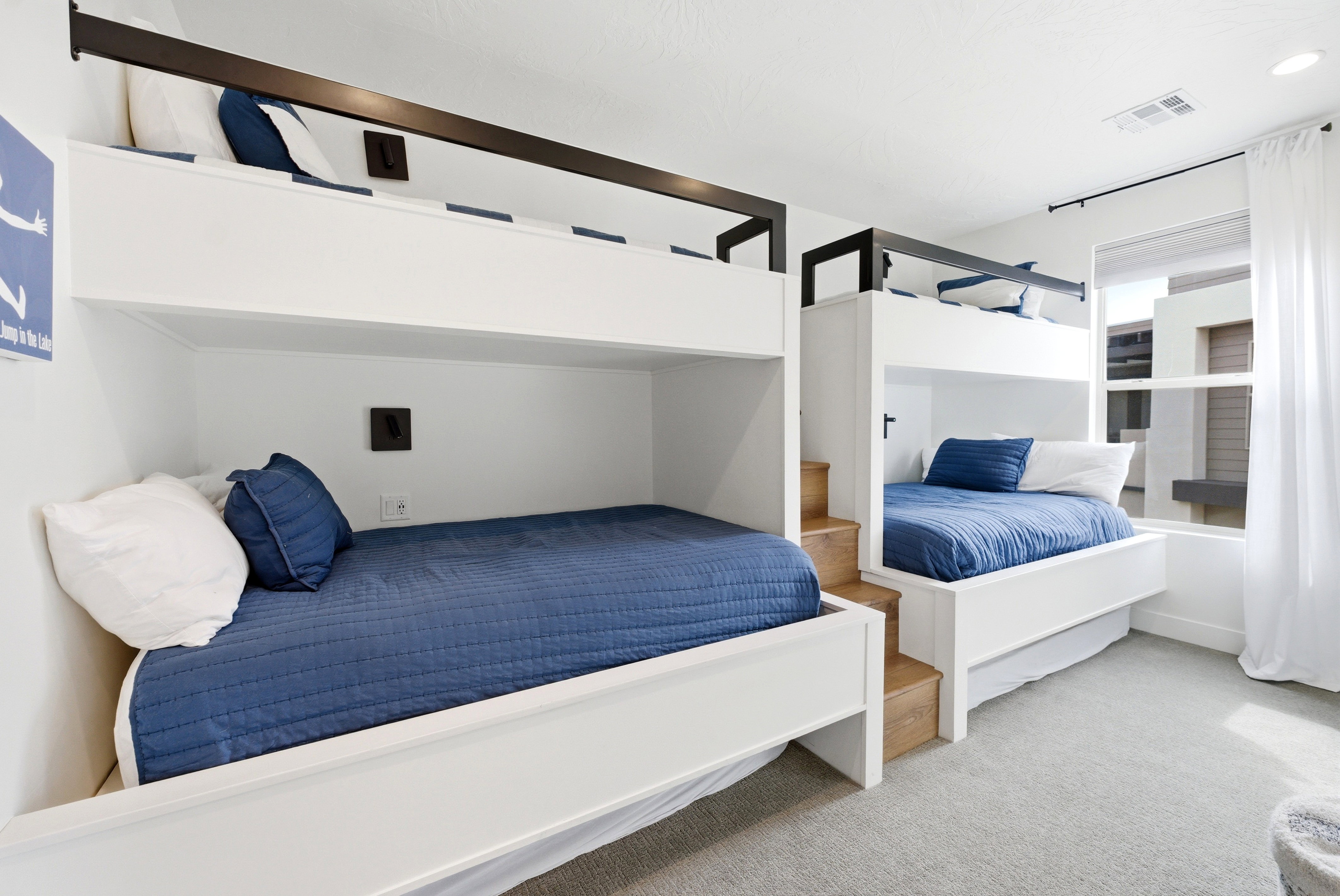Custom built-in bunk beds with integrated wooden stairs and dark metal railings