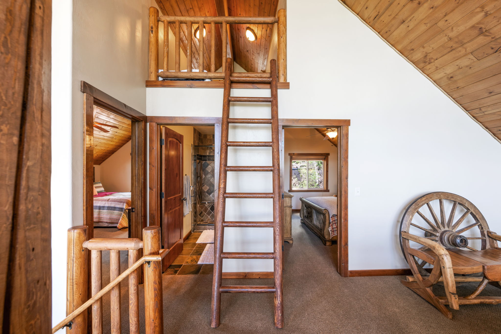 Wood-paneled ceilings with exposed beams and a log railing
