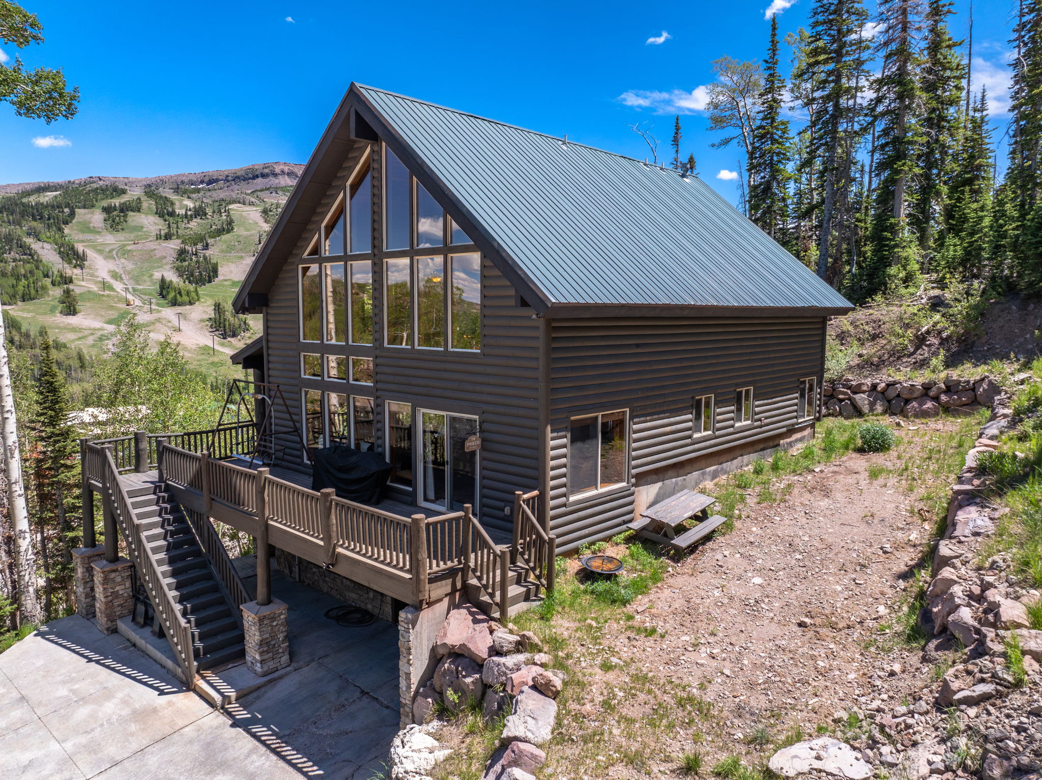 A-frame style residence featuring a metal roof and log siding