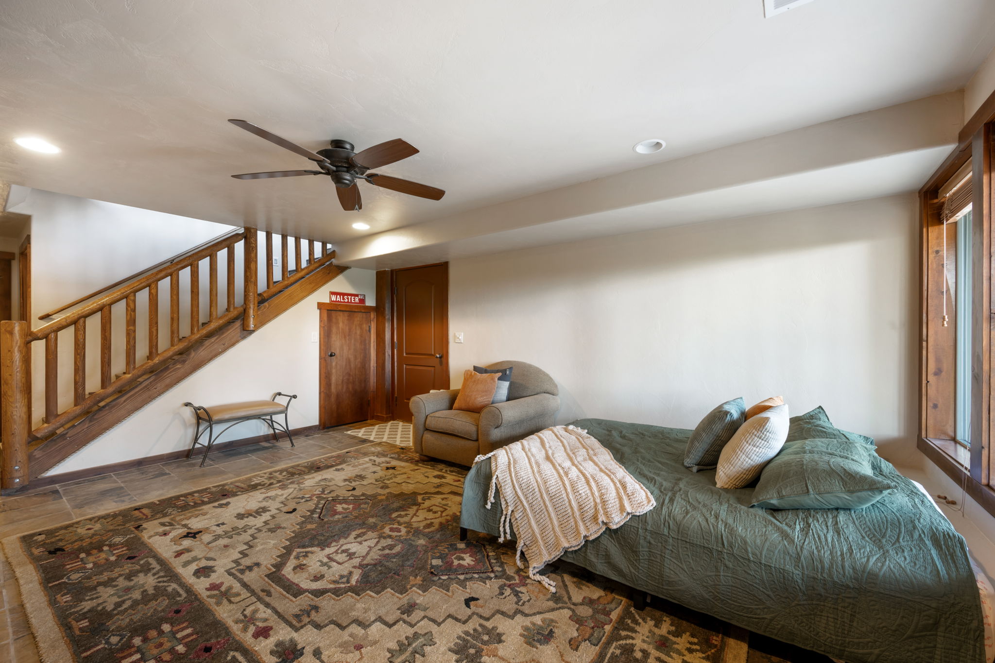 Wood-finish staircase with rustic railing, tile flooring, and recessed lighting