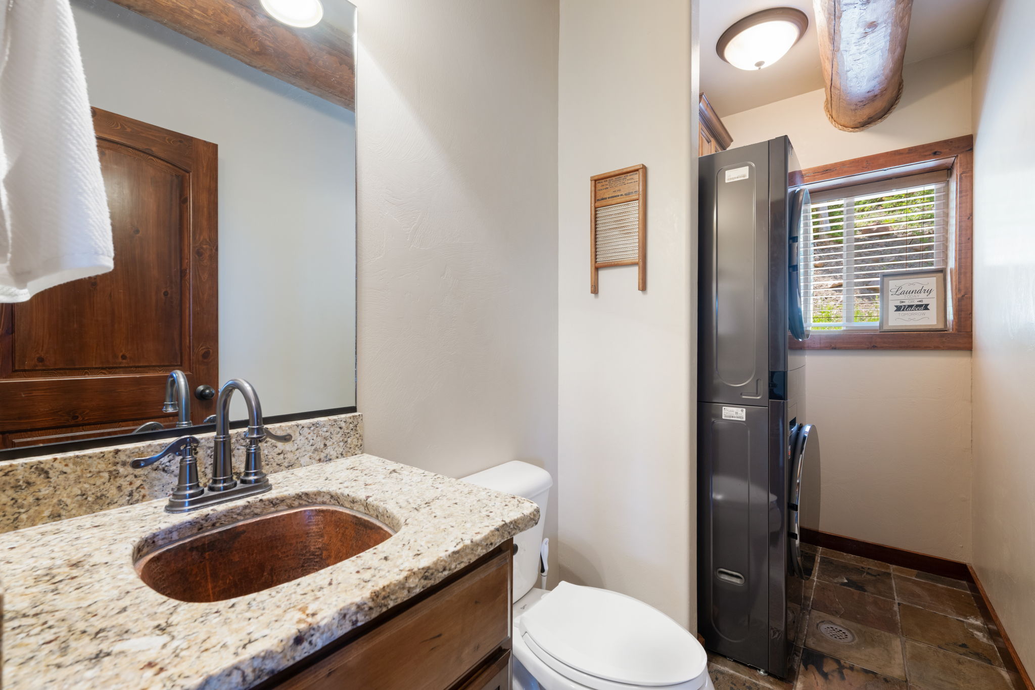 Vanity with granite countertop, copper vessel sink, and oil-rubbed bronze faucet
