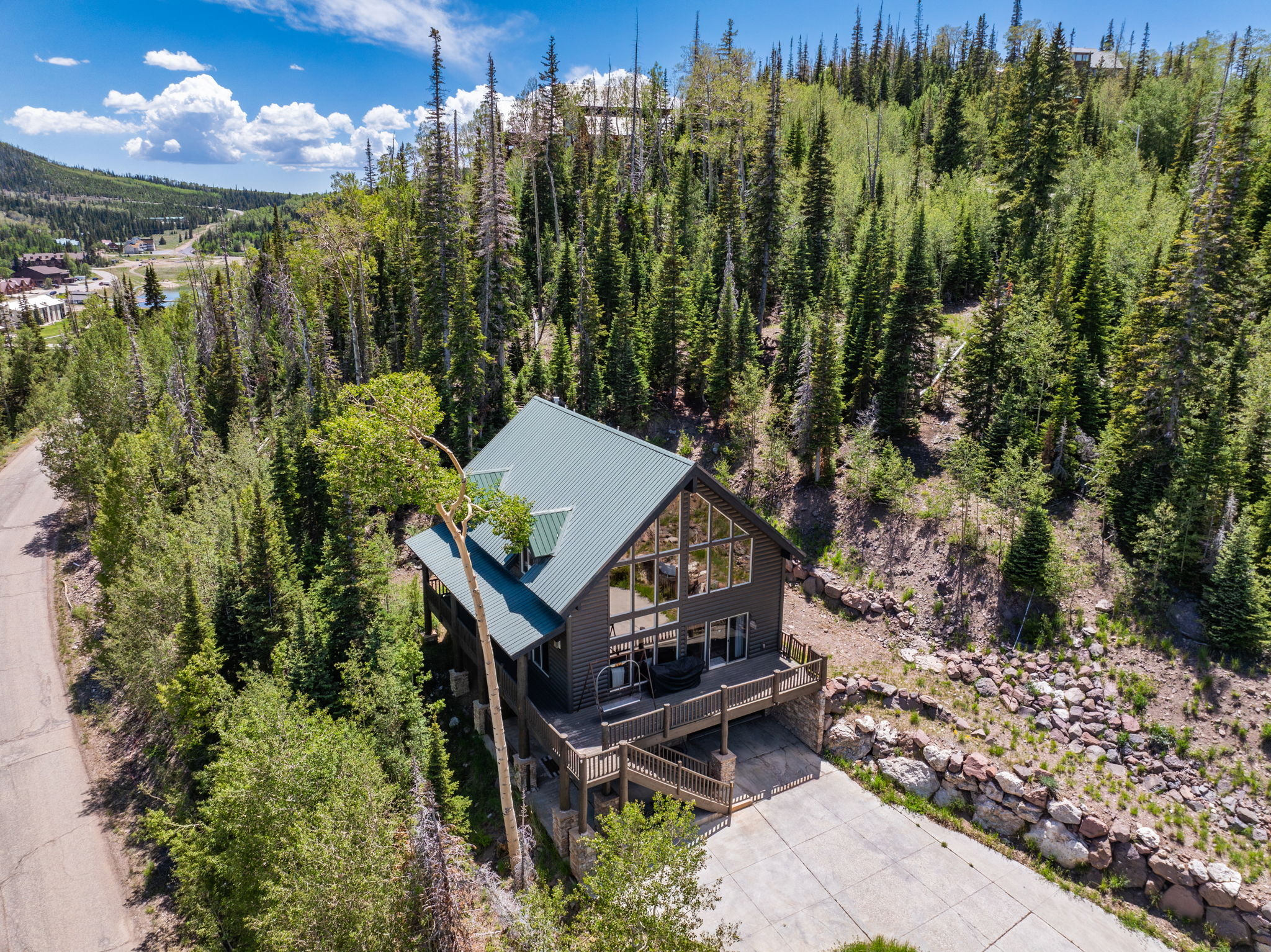 Contemporary chalet-style residence with a green metal roof and expansive glass frontage