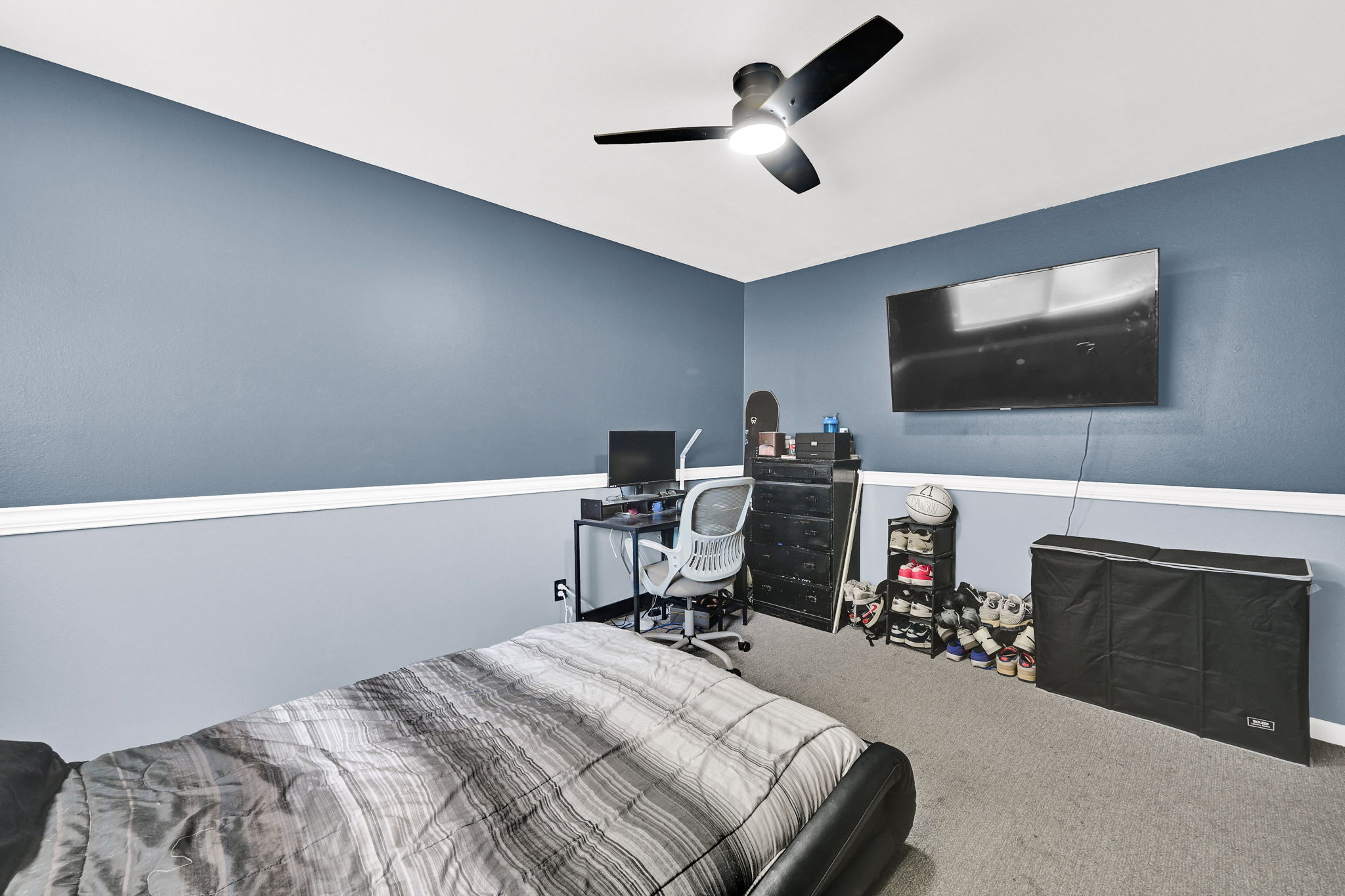 Carpeted room with a two-tone wall treatment, featuring a white chair rail molding