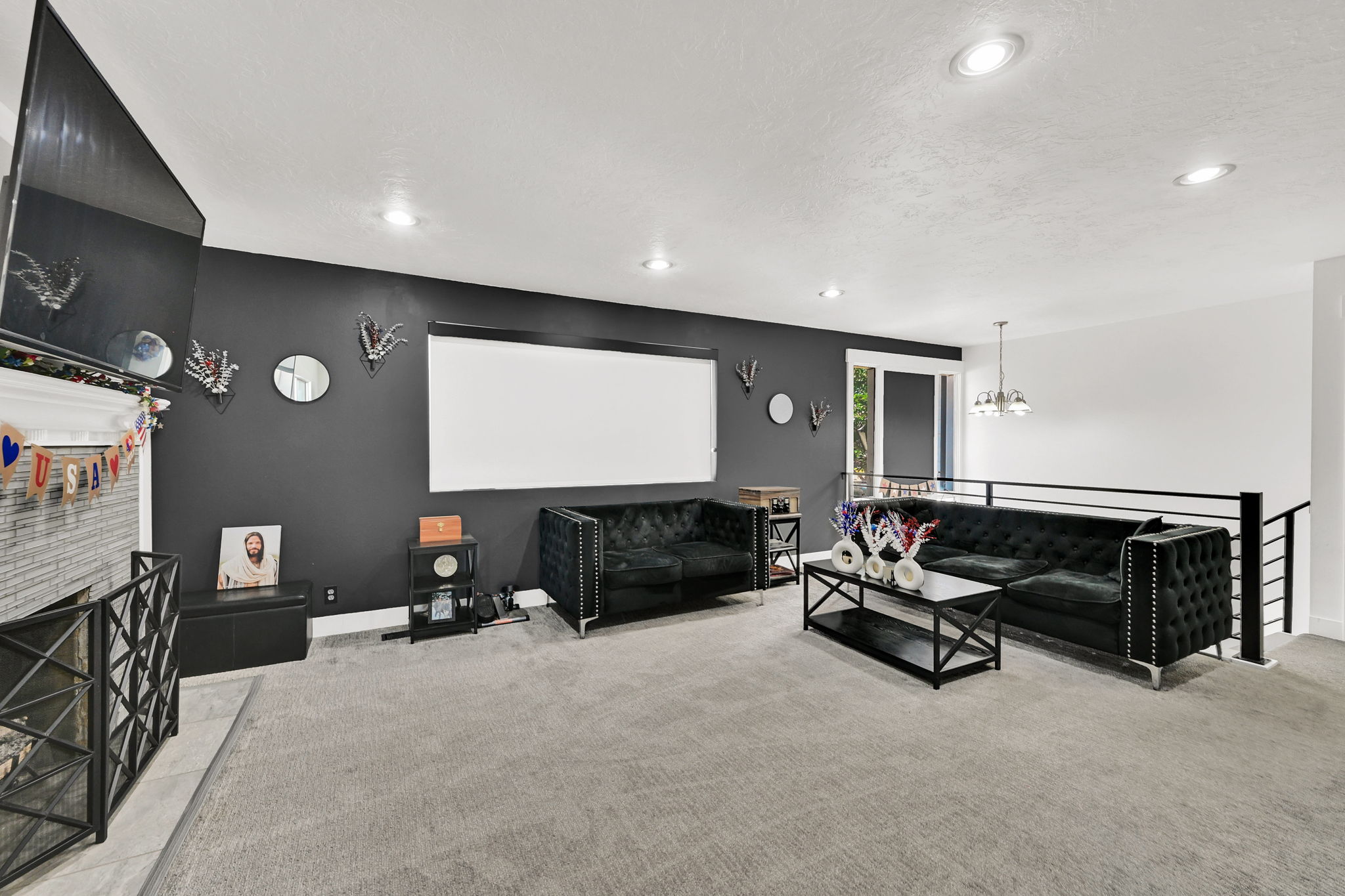 Spacious living area featuring a neutral carpet, recessed lighting, and a white projection screen