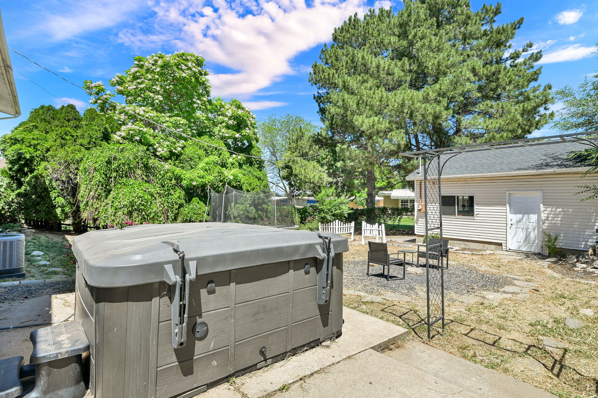 Outdoor spa on a concrete pad with a gravel patio area